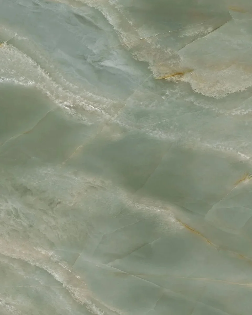 Close-up of a polished green marble surface with natural veining and patterns.