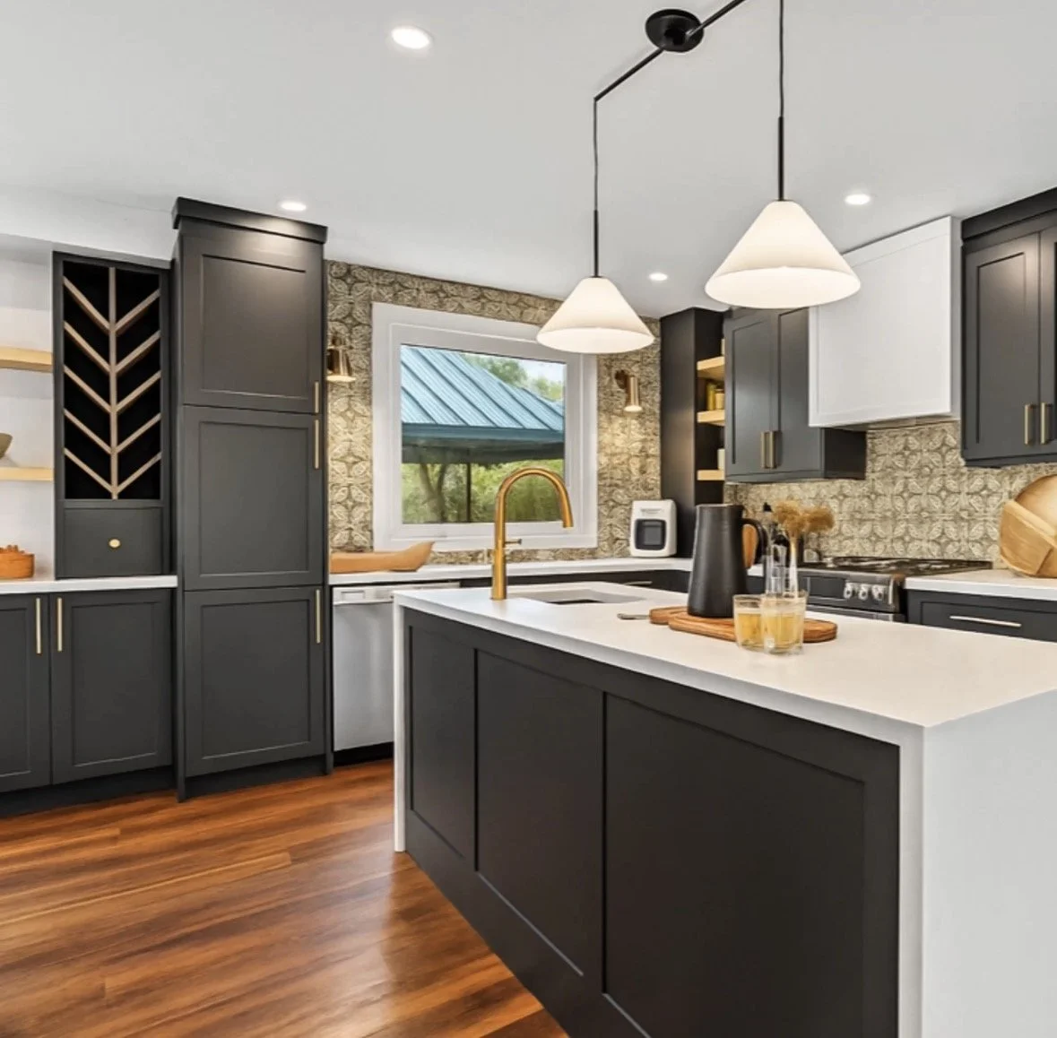 Modern kitchen with dark gray cabinets, white countertops, a kitchen island, wooden flooring, two pendant lights, and a window showing a porch with a blue roof.