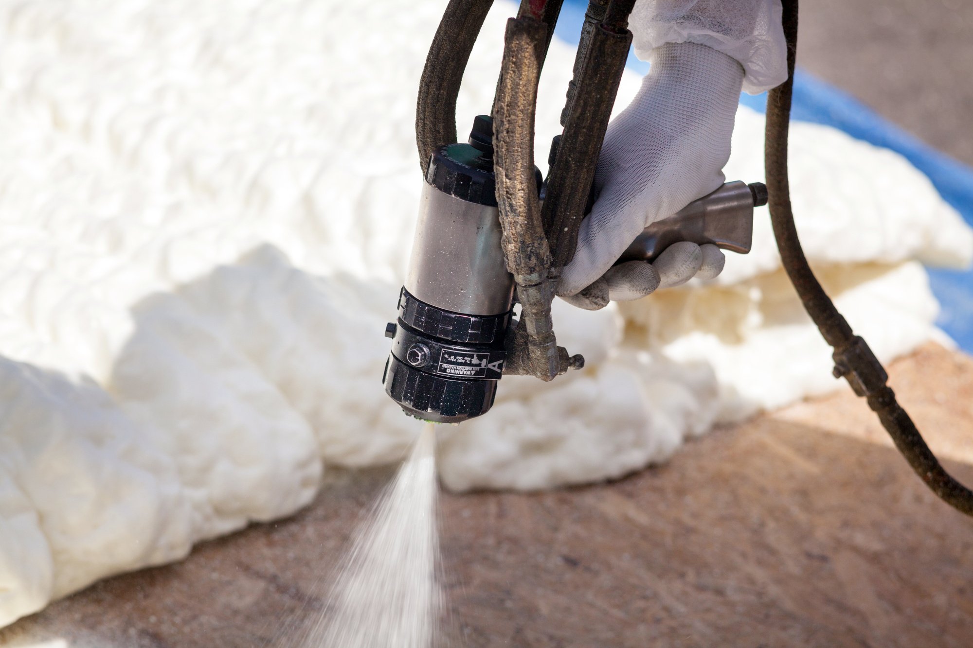 A person installing spray foam insulation..