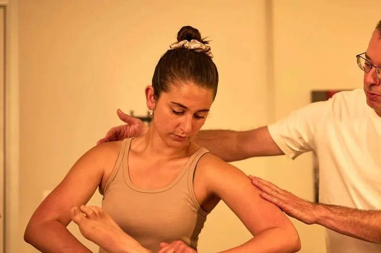 Une femme reçoit un massage du bras par un thérapeute dans une pièce chaleureuse.