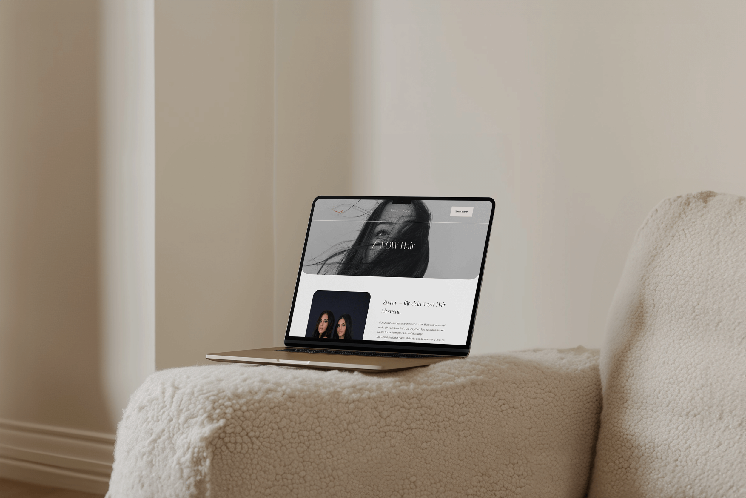 Ein Laptop auf einer weichen, beige Couch mit einer Website für Wow Hair