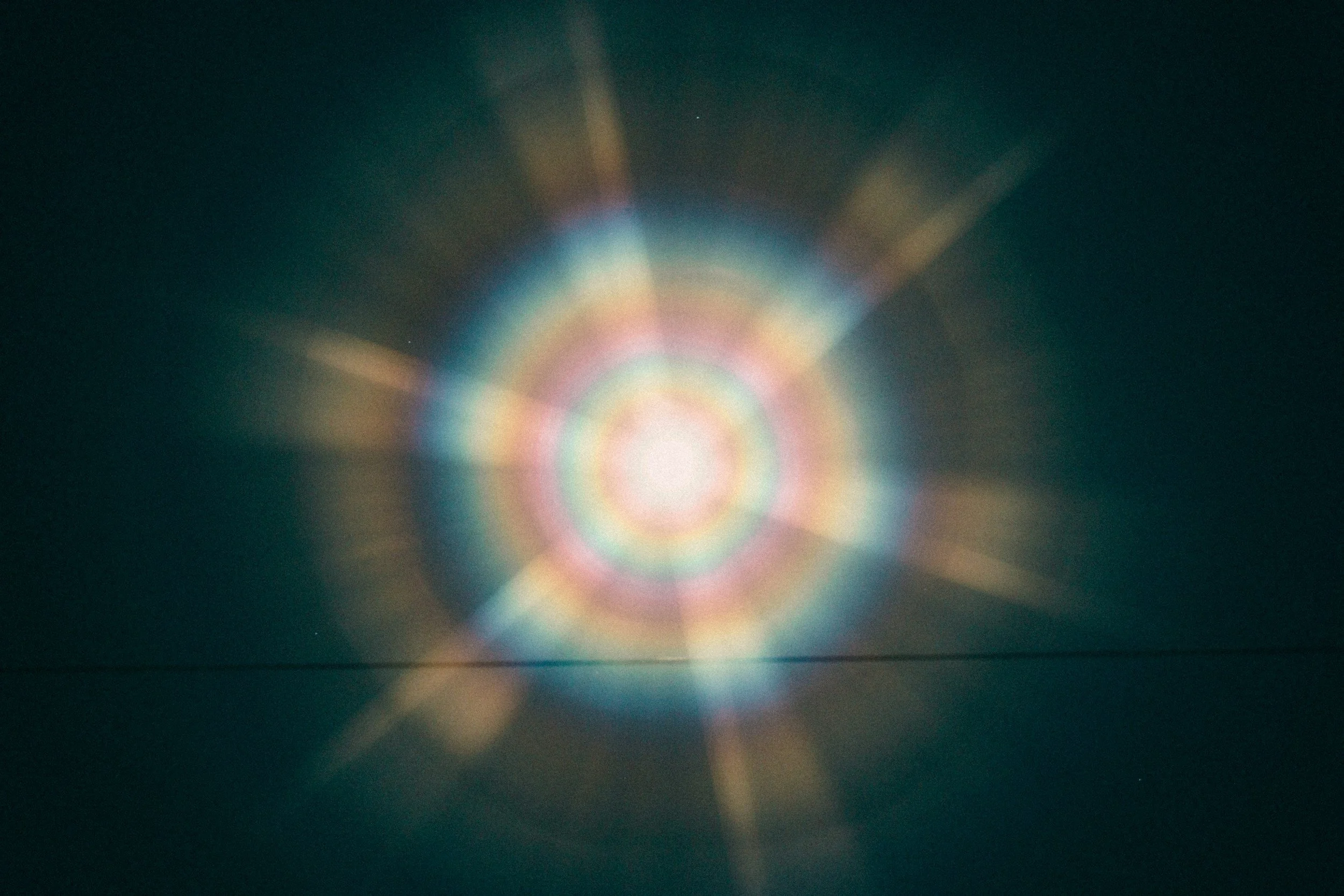 Lichtreflexionen in der Dunkelheit, die einen bunten Regenbogen-Effekt erzeugen.