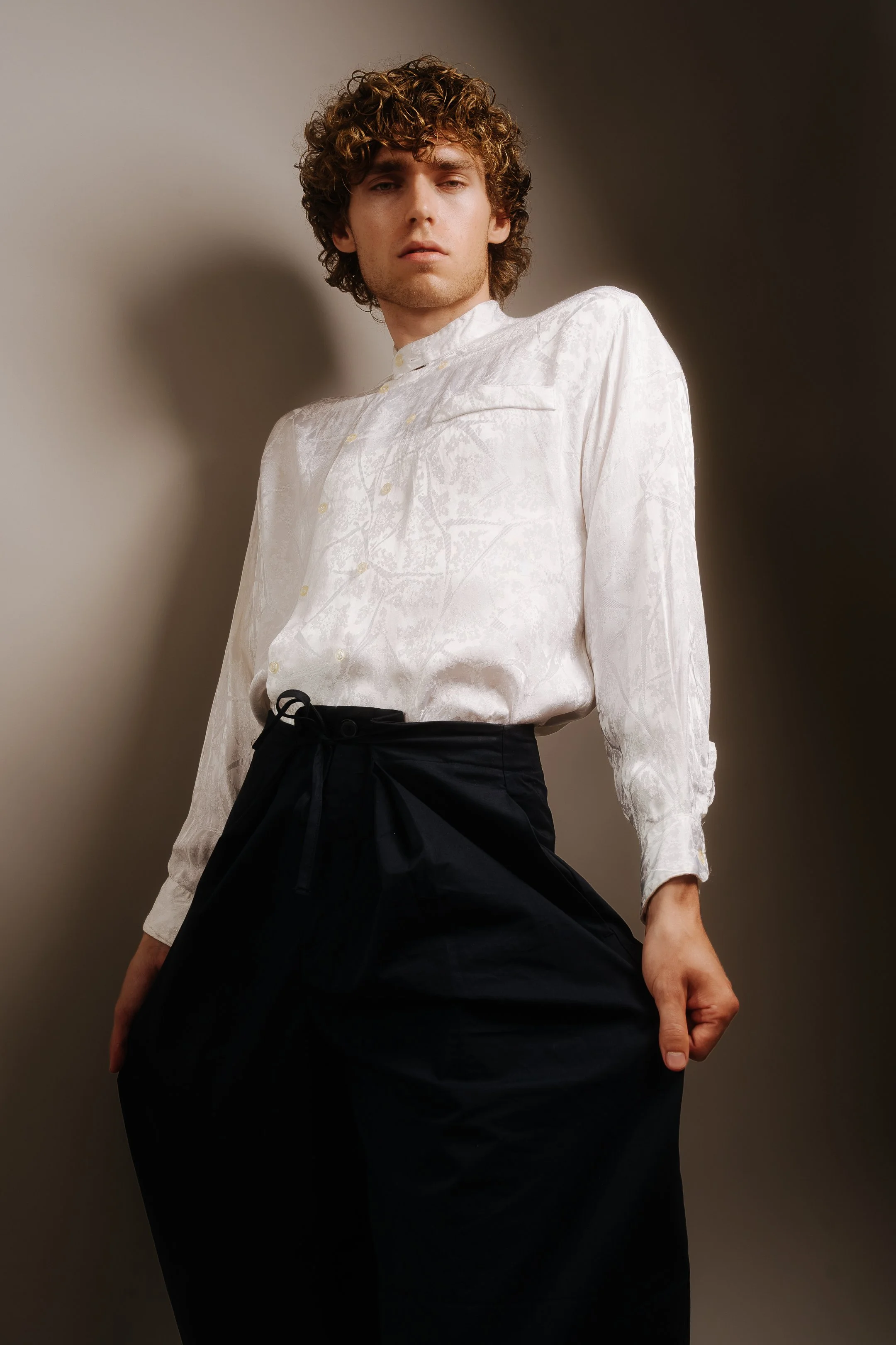 A refined studio portrait combining fashion, sculptural posing and soft directional light.