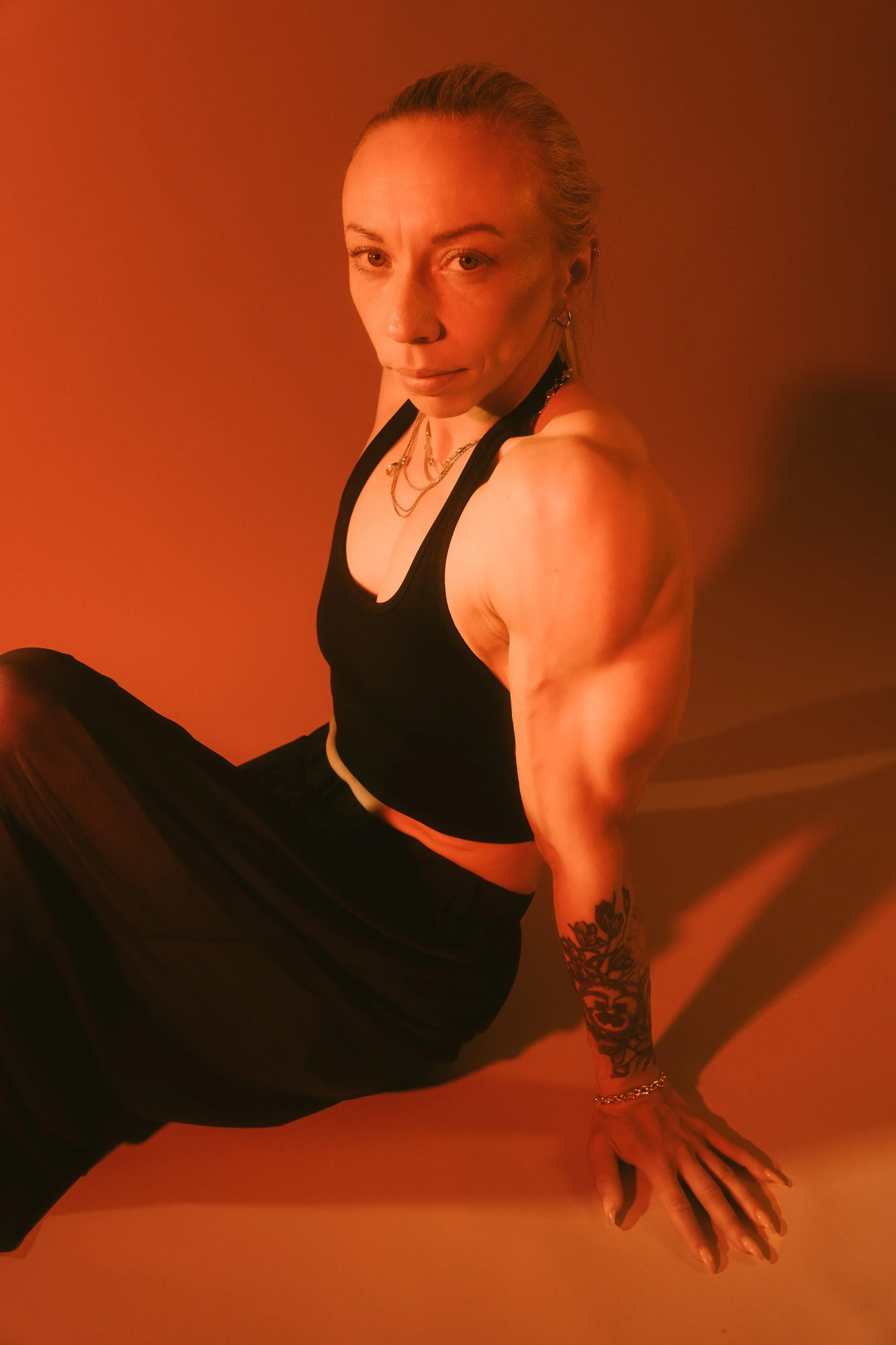 A bold portrait shaped by intense red light, strong shadows and a powerful presence.