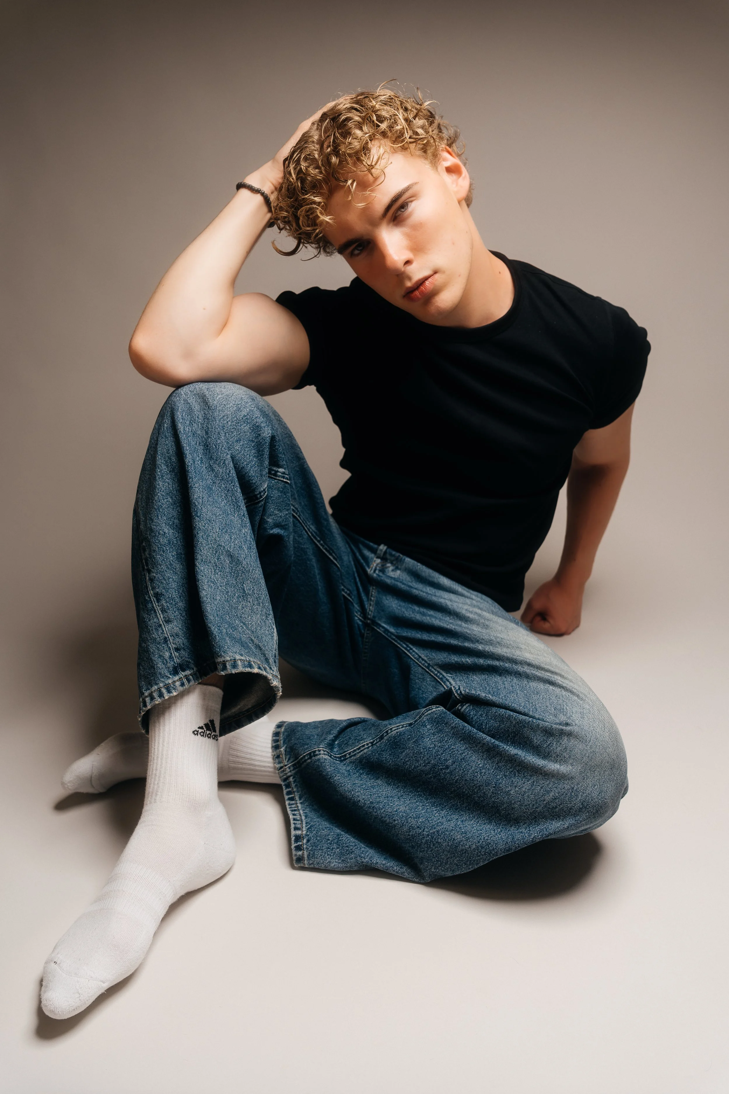 A relaxed studio portrait balancing contemporary fashion, natural movement and a confident attitude.