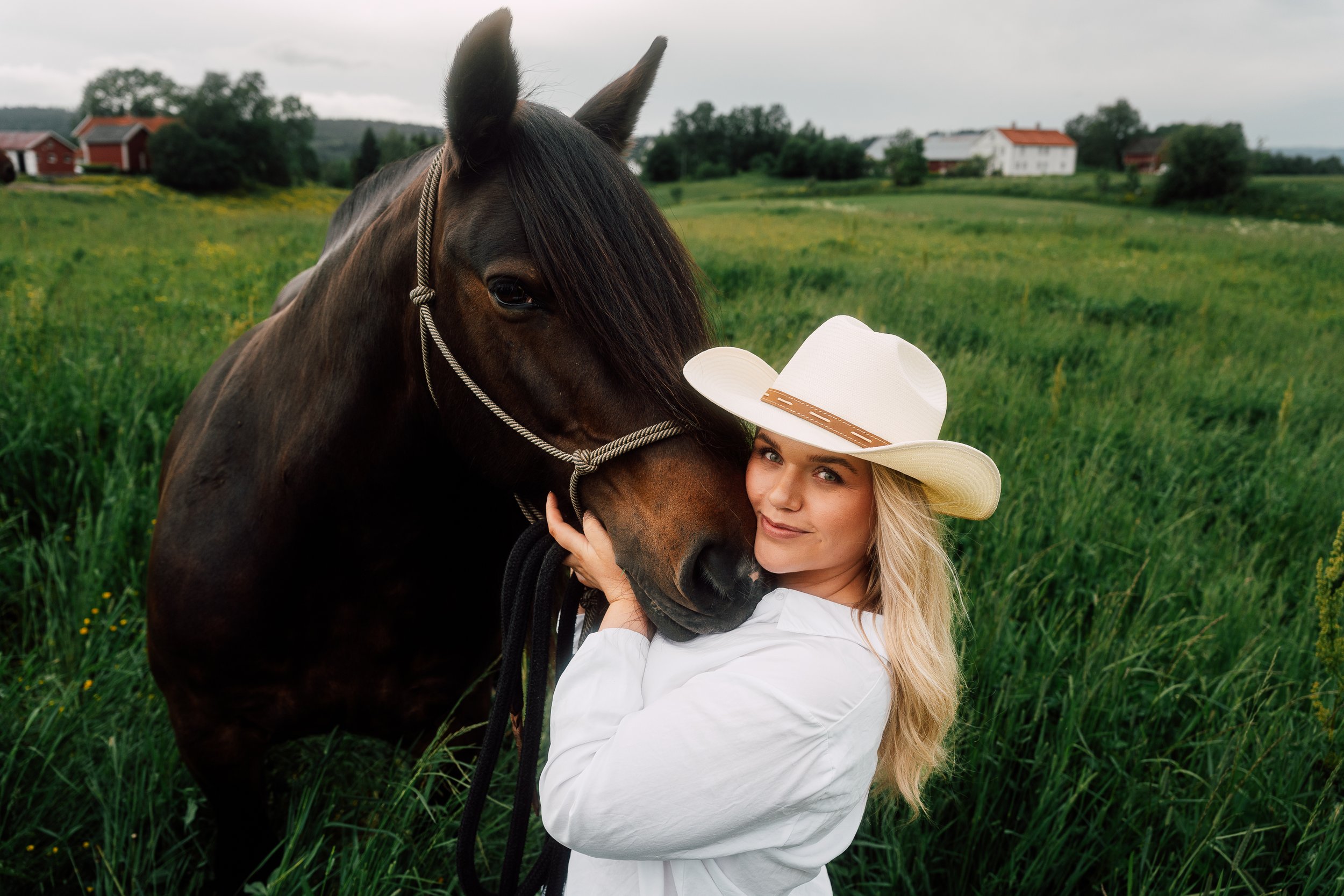 A quiet portrait connecting subject and animal within a natural rural landscape.