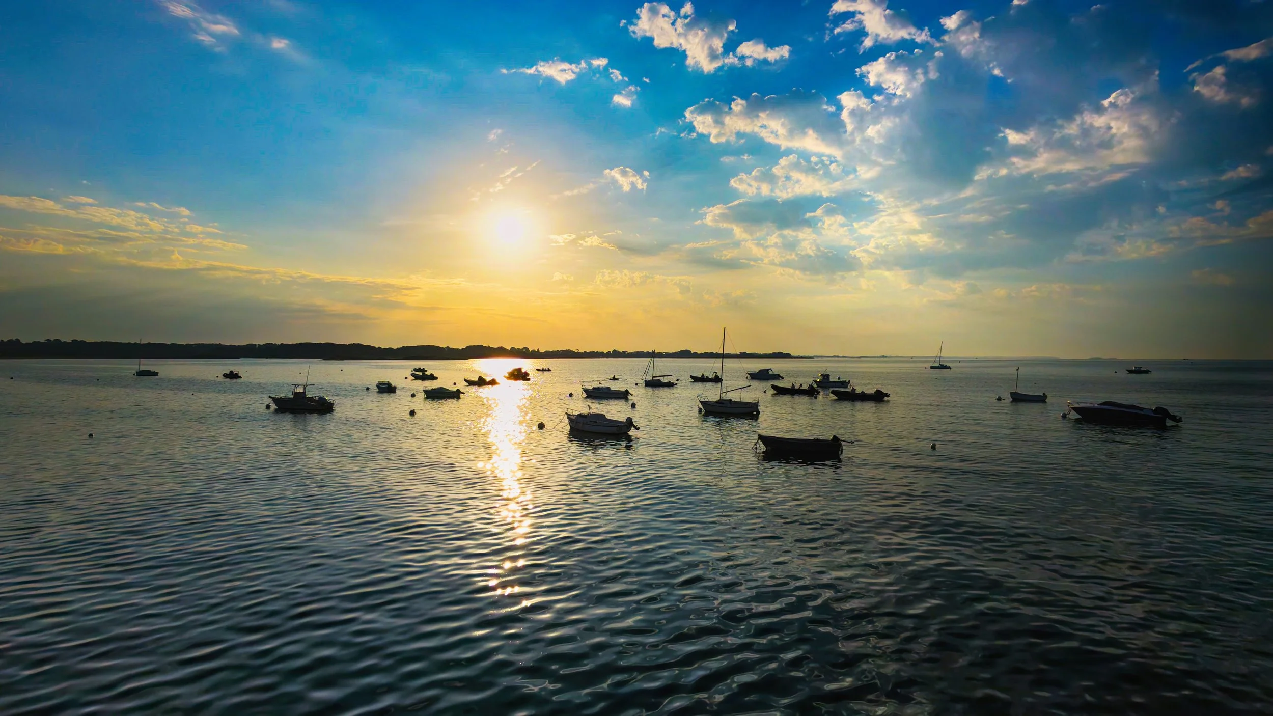 "Sunrise Boats"  A flotilla of small boats peacefully moored off Beaumer Point, Carnac, France. This Drone image captures the rising sun burning through the clouds and blessing the sea with its warmth. High dynamic range adds to the allure of the vis
