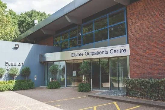 Exterior view of Elstree Outpatients Centre building with glass doors, windows, and surrounding greenery