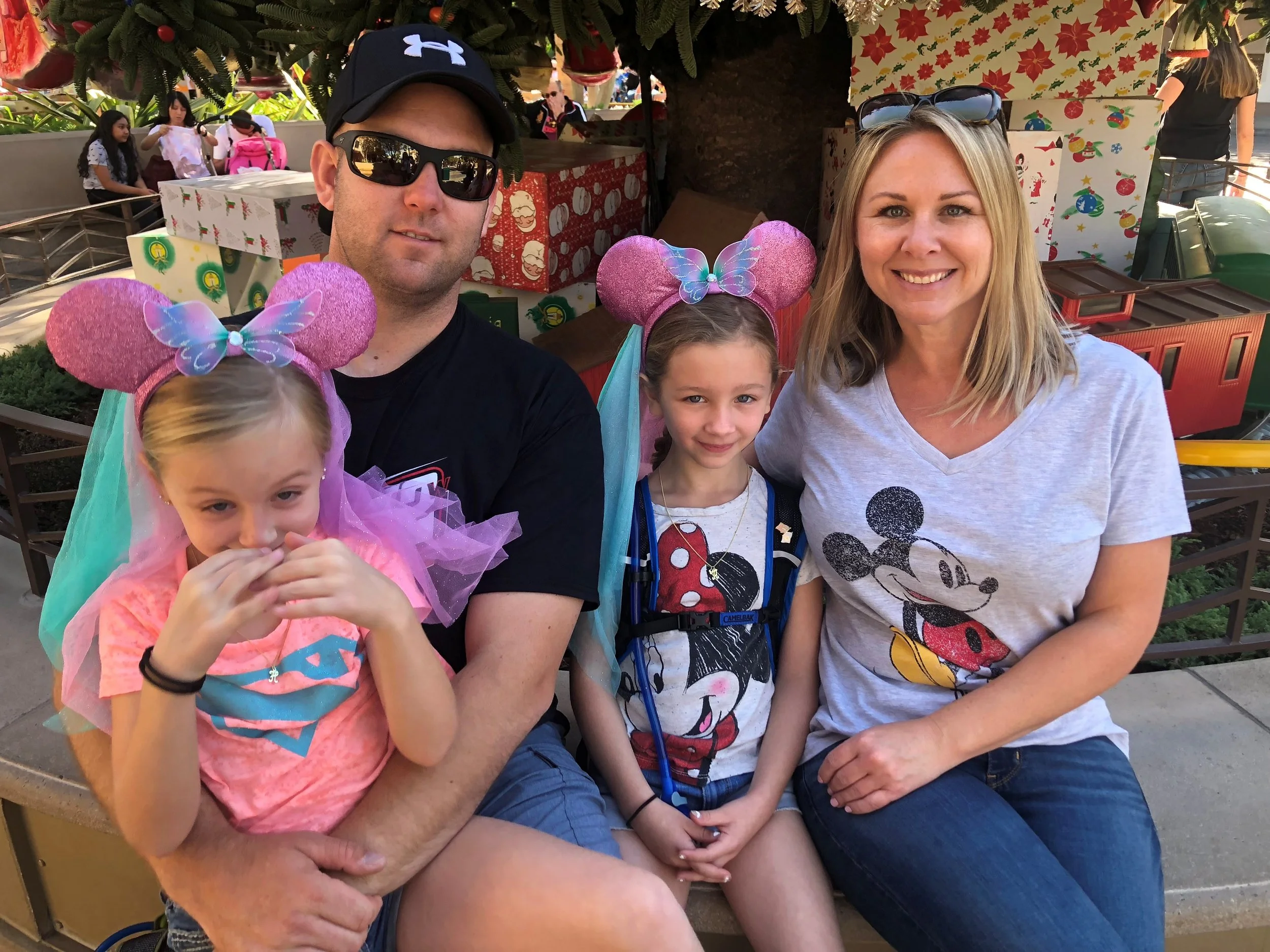 Dress Right founder with his wife and two daughters, smiling together at a family outing.
