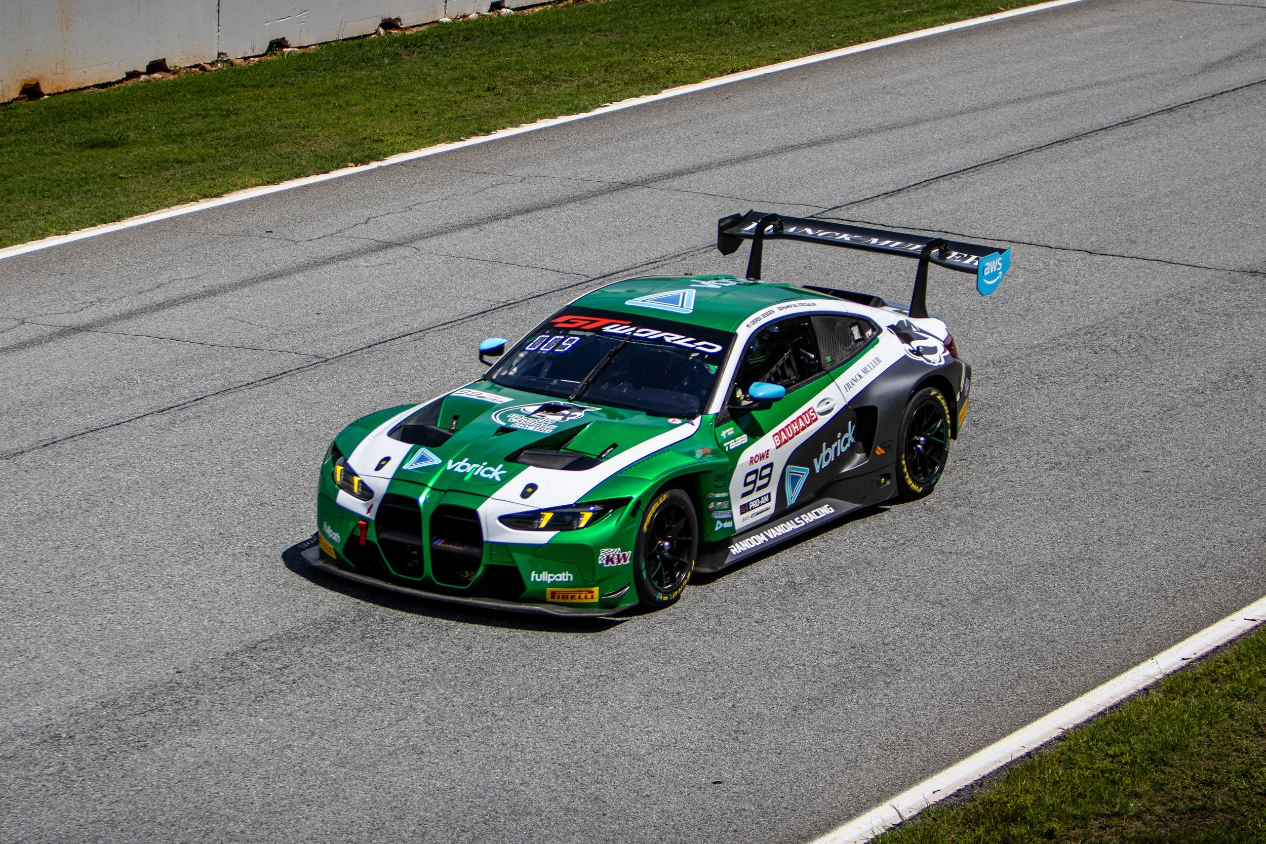Green and black race car with sponsor logos, number 99, on a race track.