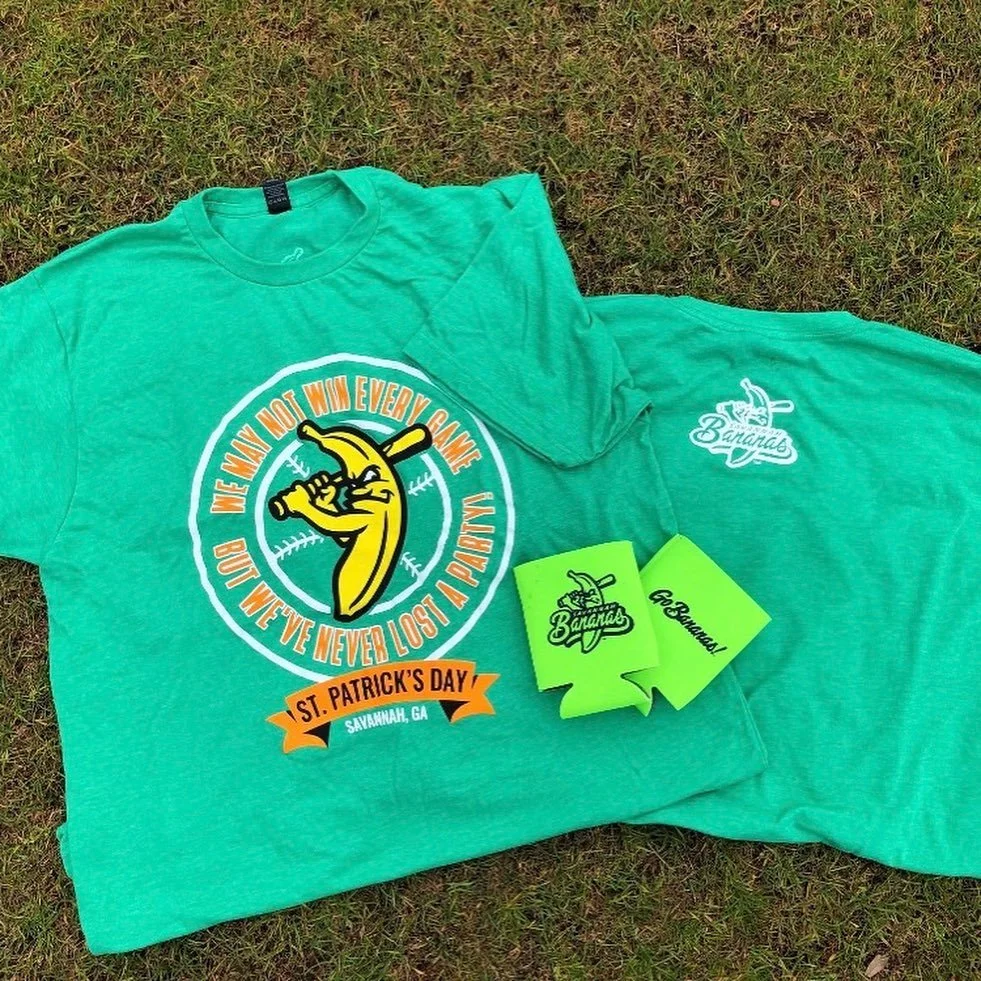 Green T-shirt with the logo of a banana holding a baseball bat and the text 'Me may not win every game but we’ve never lost a point' with a banner below saying 'St. Patrick's Day Savannah, GA'. Also, a green towel with the words 'The Bananas' and a b