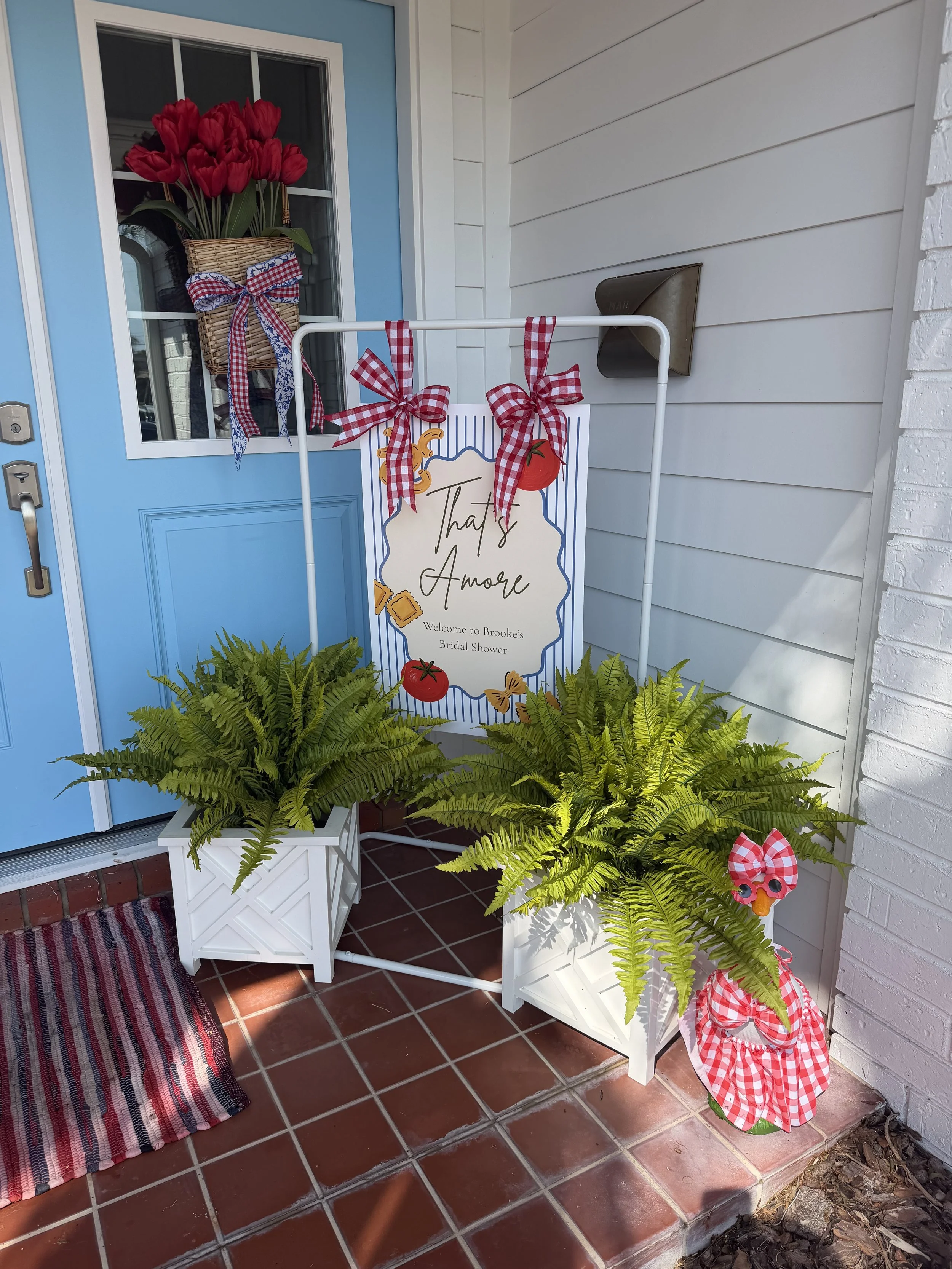 FSU-themed event welcome display with a custom sign, potted ferns, and red and blue decorative accents.