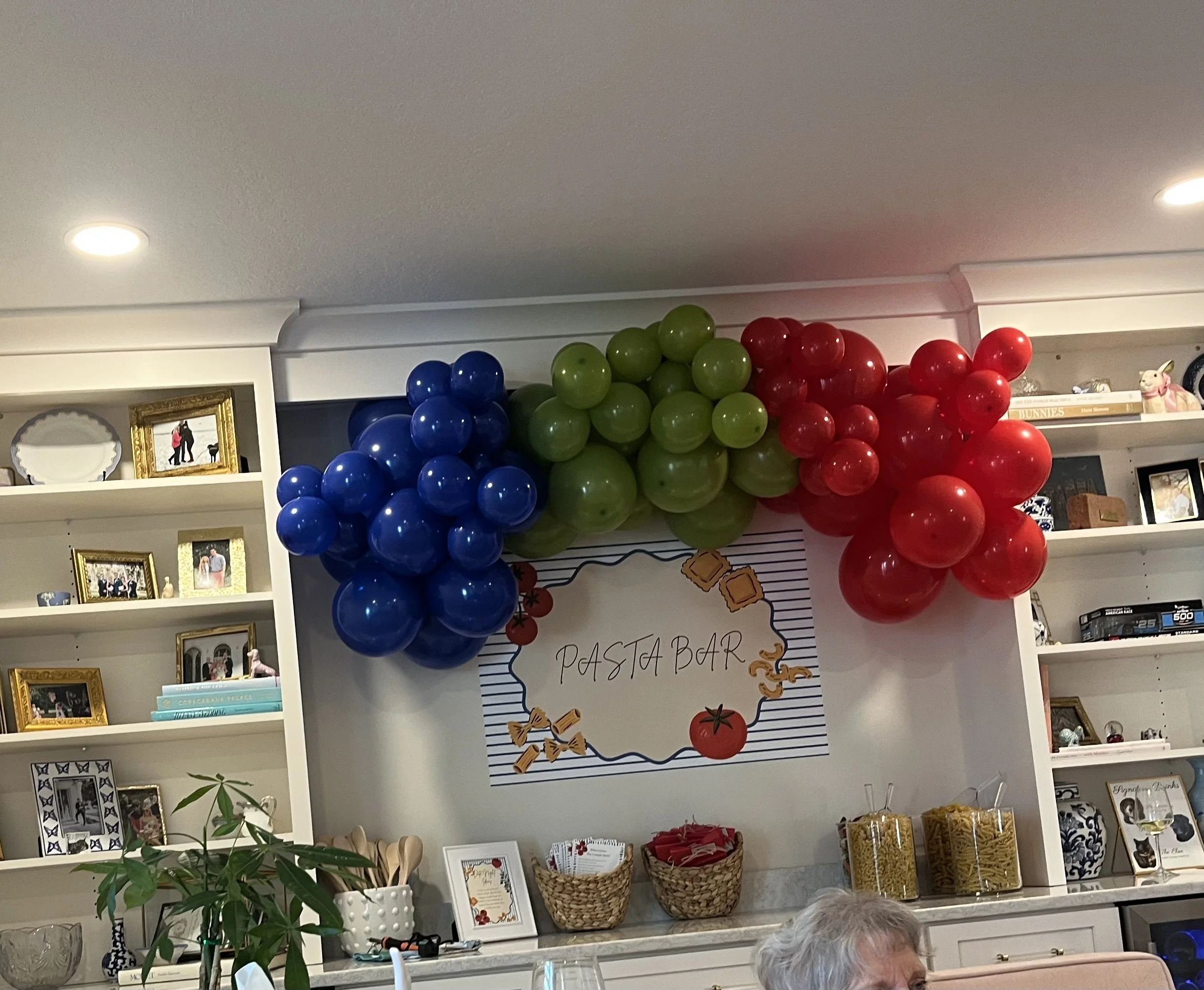 Indoor FSU party setup with a red, blue, and green balloon garland and styled display table.