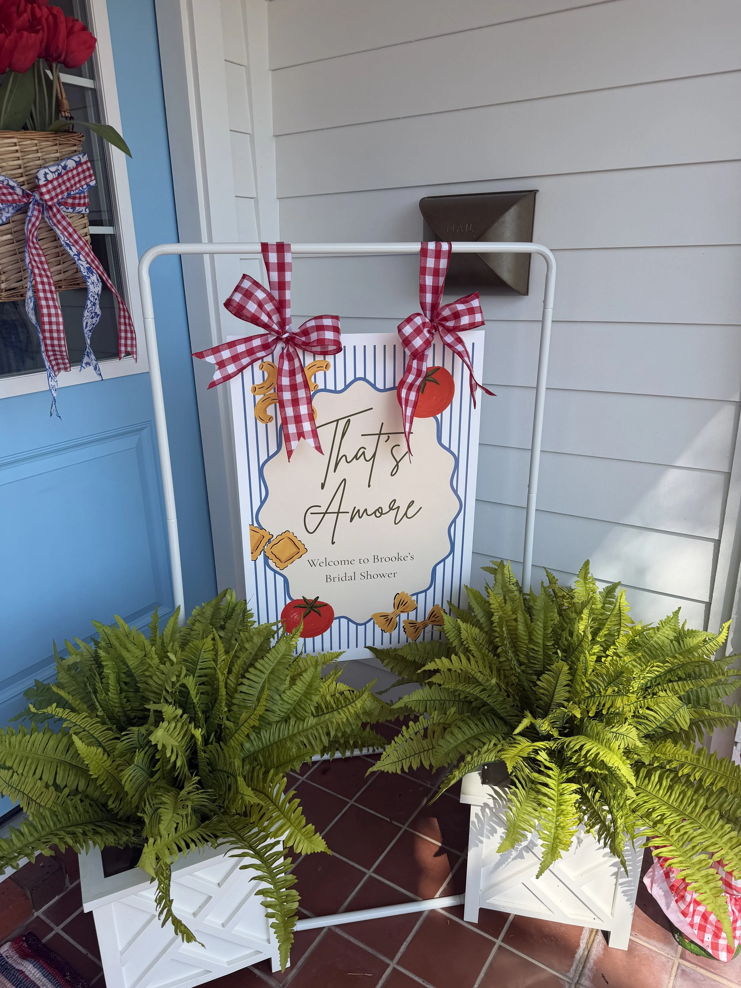 FSU-themed welcome sign with red and blue accents displayed between potted ferns at an outdoor entrance.