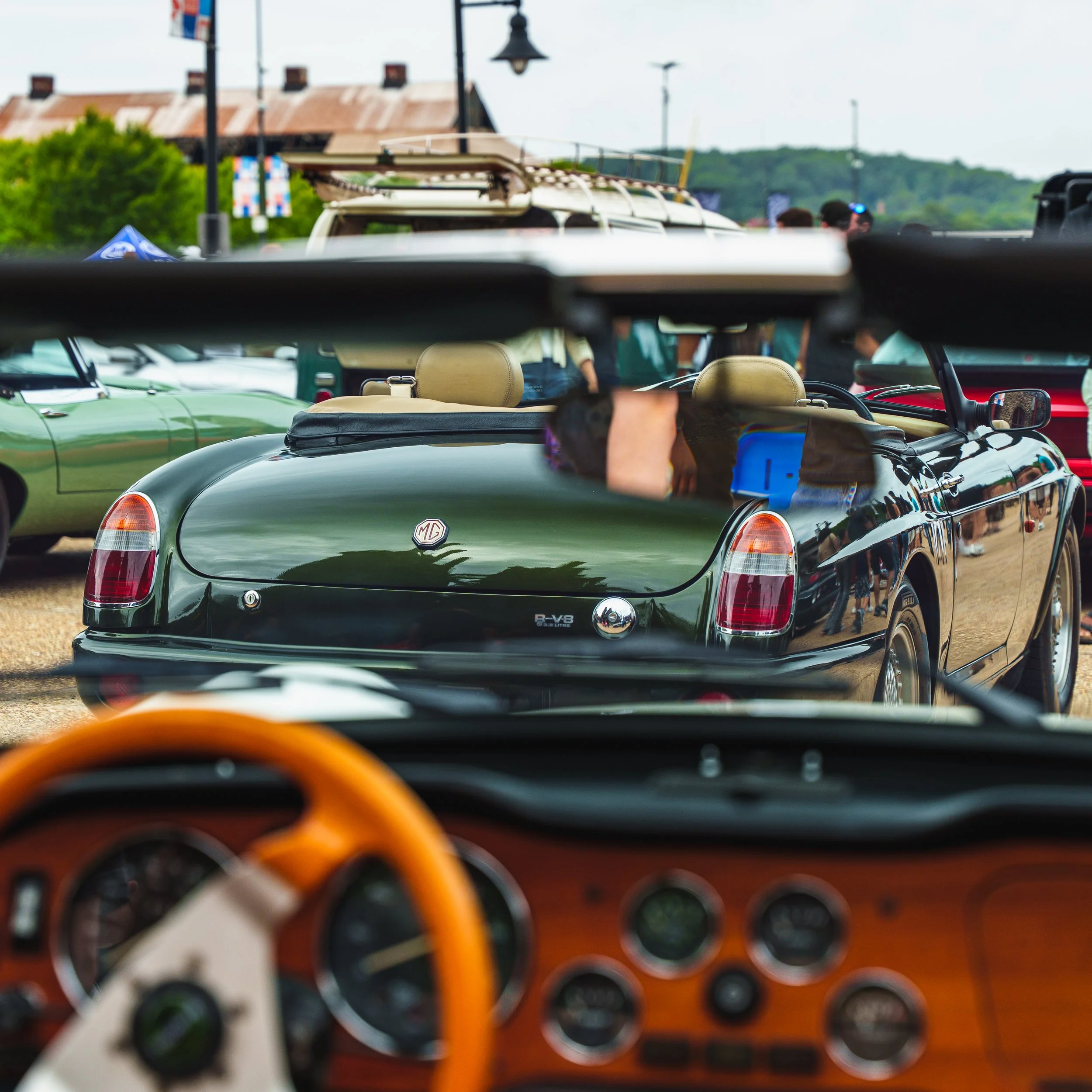 View of the dashboard and steering wheel interior of a classic cruiser car from the driver's perspective, with multiple round gauges and orange accents.