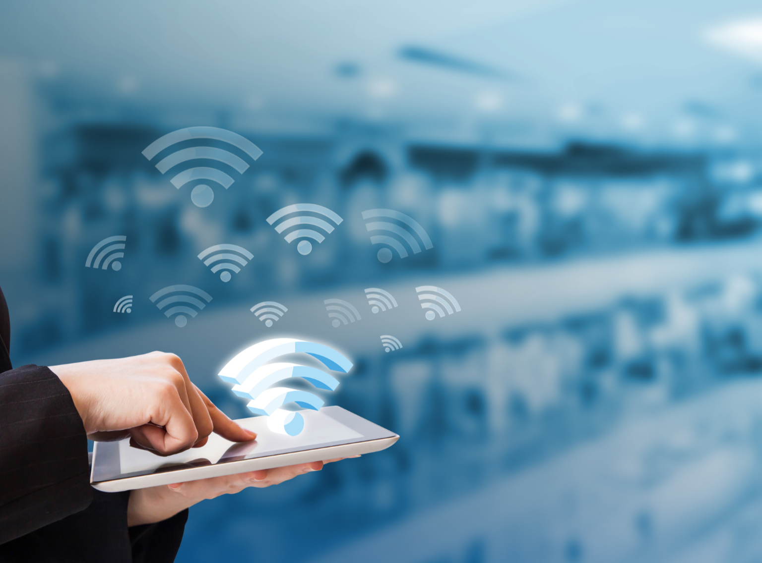 Person holding a tablet with a digital Wi-Fi symbol emanating from it, over a blurred indoor background.