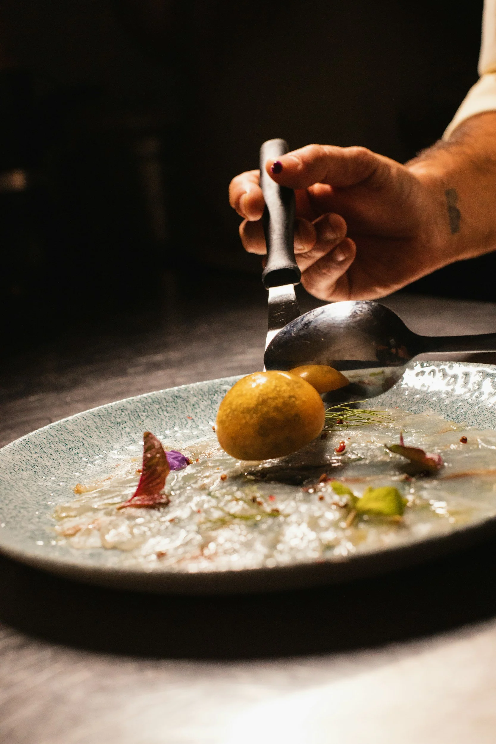 Private chef precisely plating a luxury fine dining dish for a catering quote request in Phoenix