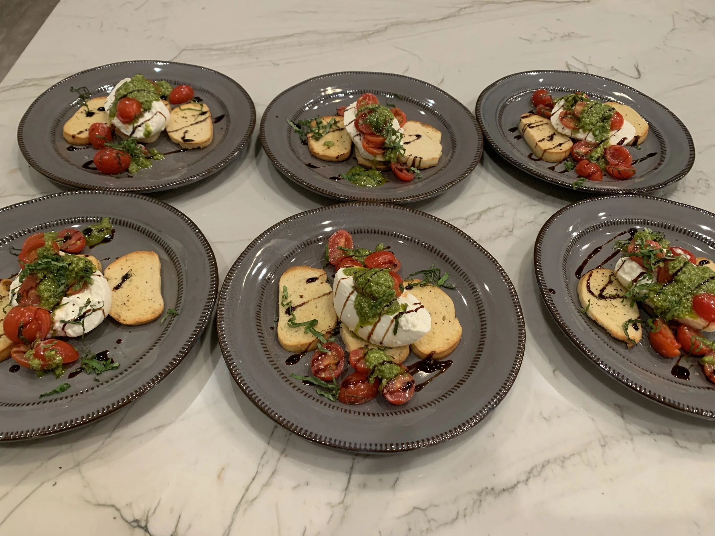 Deconstructed Baratta salad with crostini, grape tomatoes, basil pesto and balsamic glaze for a private event in Cave Creek, AZ. 