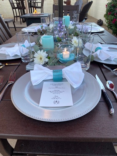 Elegant table setting with silver charger setting in tiffany blue colors with illuminated luxurious center pieces.