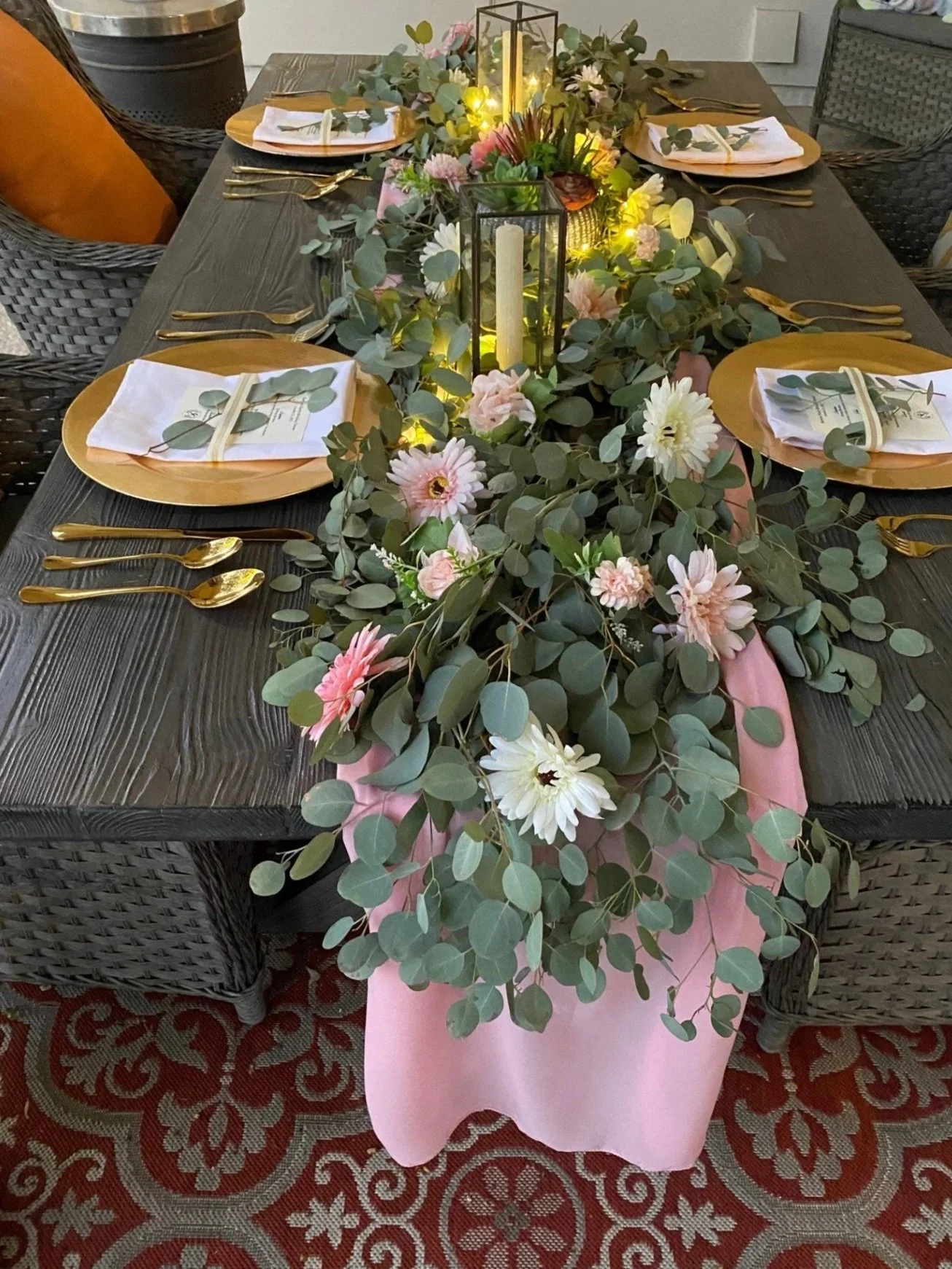 Luxury dining table with floral centerpiece, candles, gold utensils, and six place settings styled for an immersive private chef experience.
