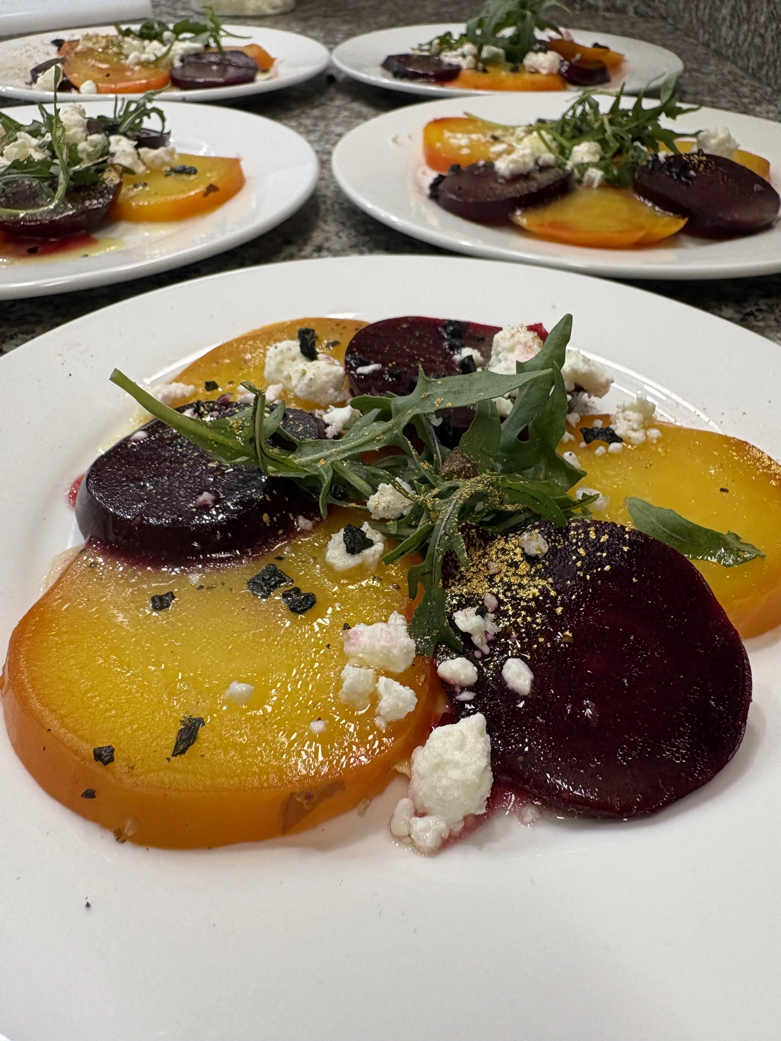 Smoked beet carpaccio with gold‑flecked vinaigrette, plated for Chef Dean’s Traitors‑themed luxury dinner party.