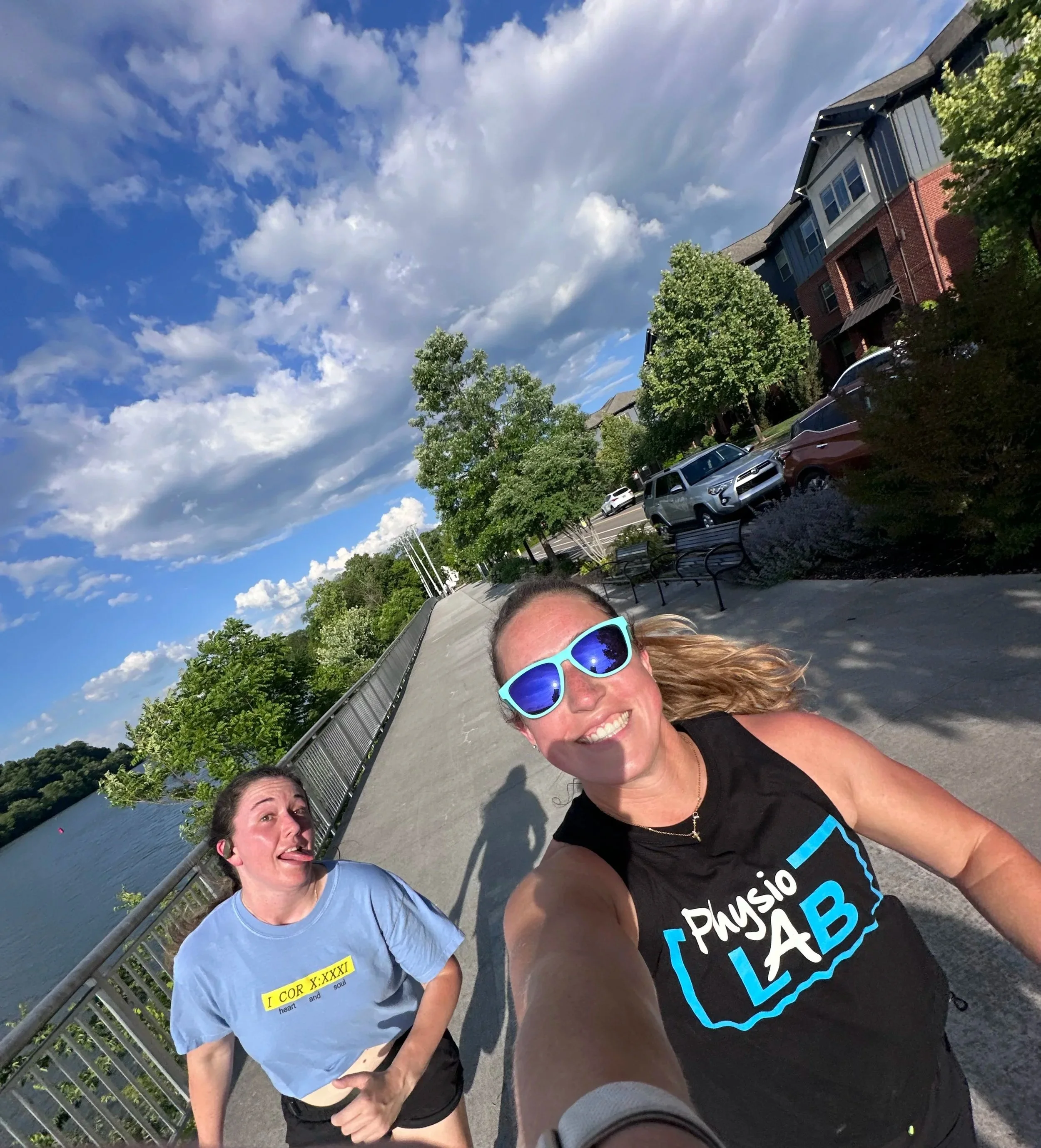 A Physio Lab provider jogging with another individual along the riverfront