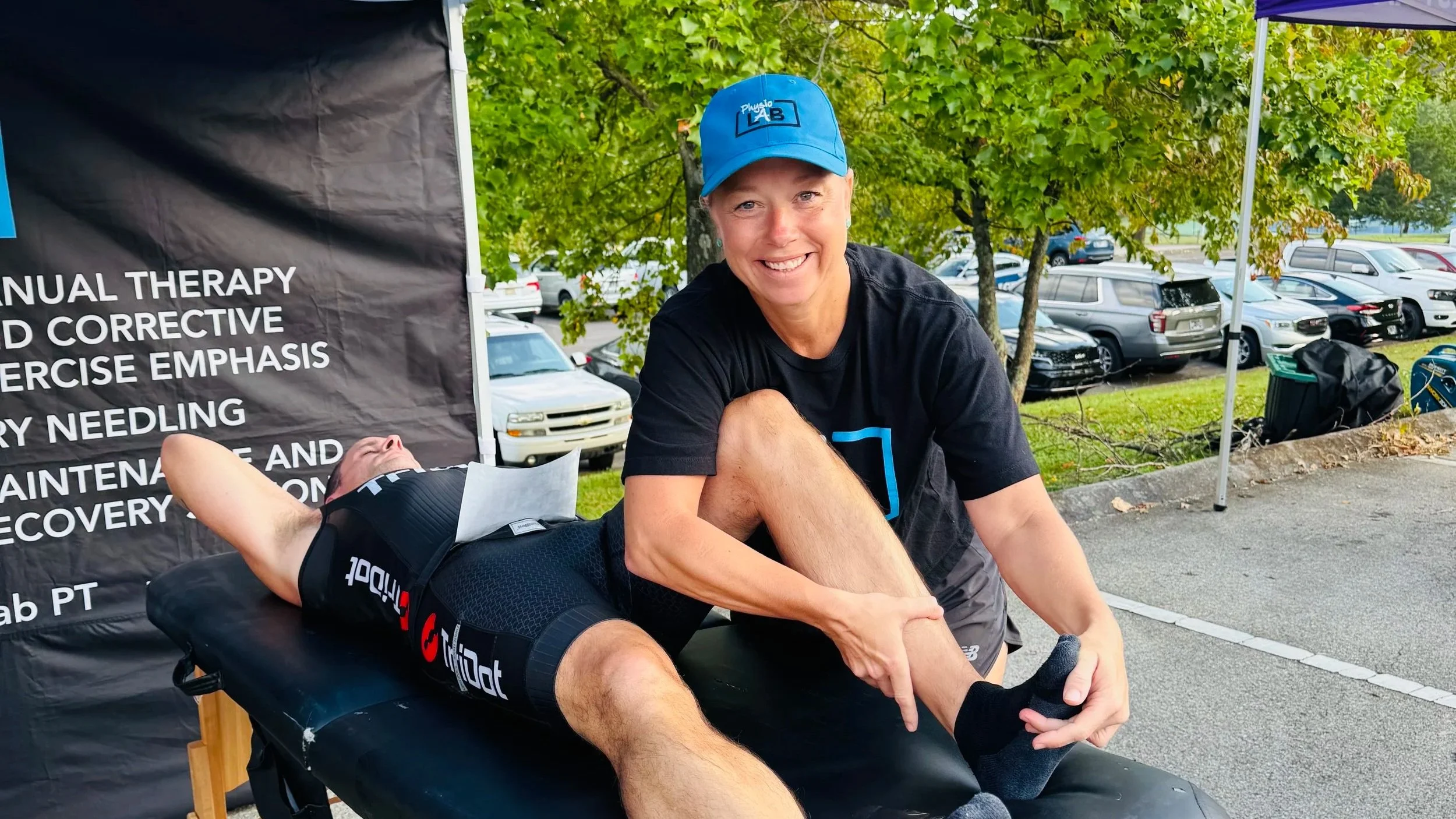 A stretch therapist stretching a runner's calf after a race