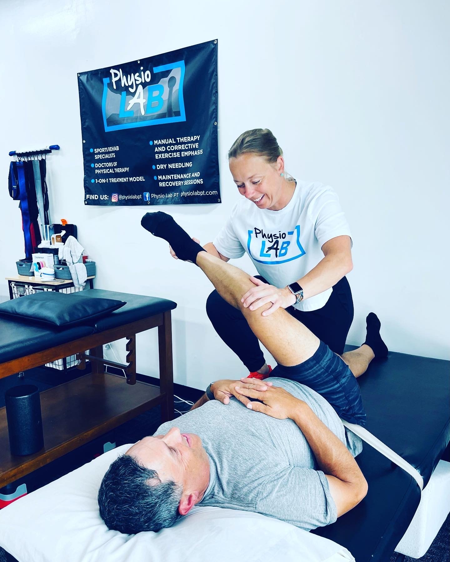 Physical therapy session with a therapist stretching a patient's leg in a clinic.