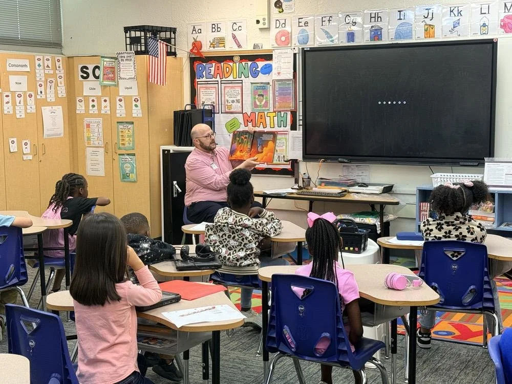 Commissioner David O’Keefe reads to a classroom of children at Kate Sullivan Elementary School.