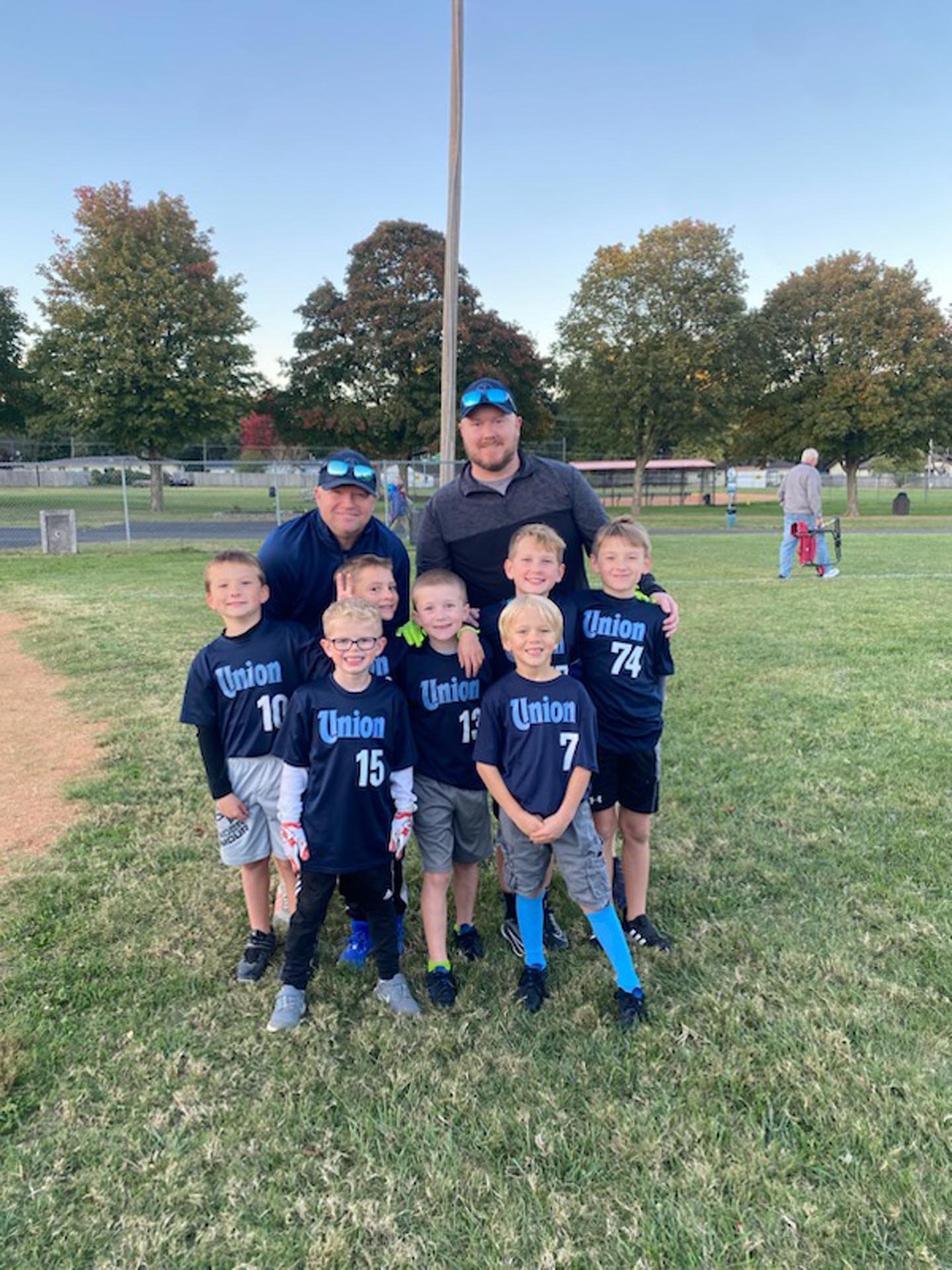 A group of young boys in navy blue sports uniforms with 