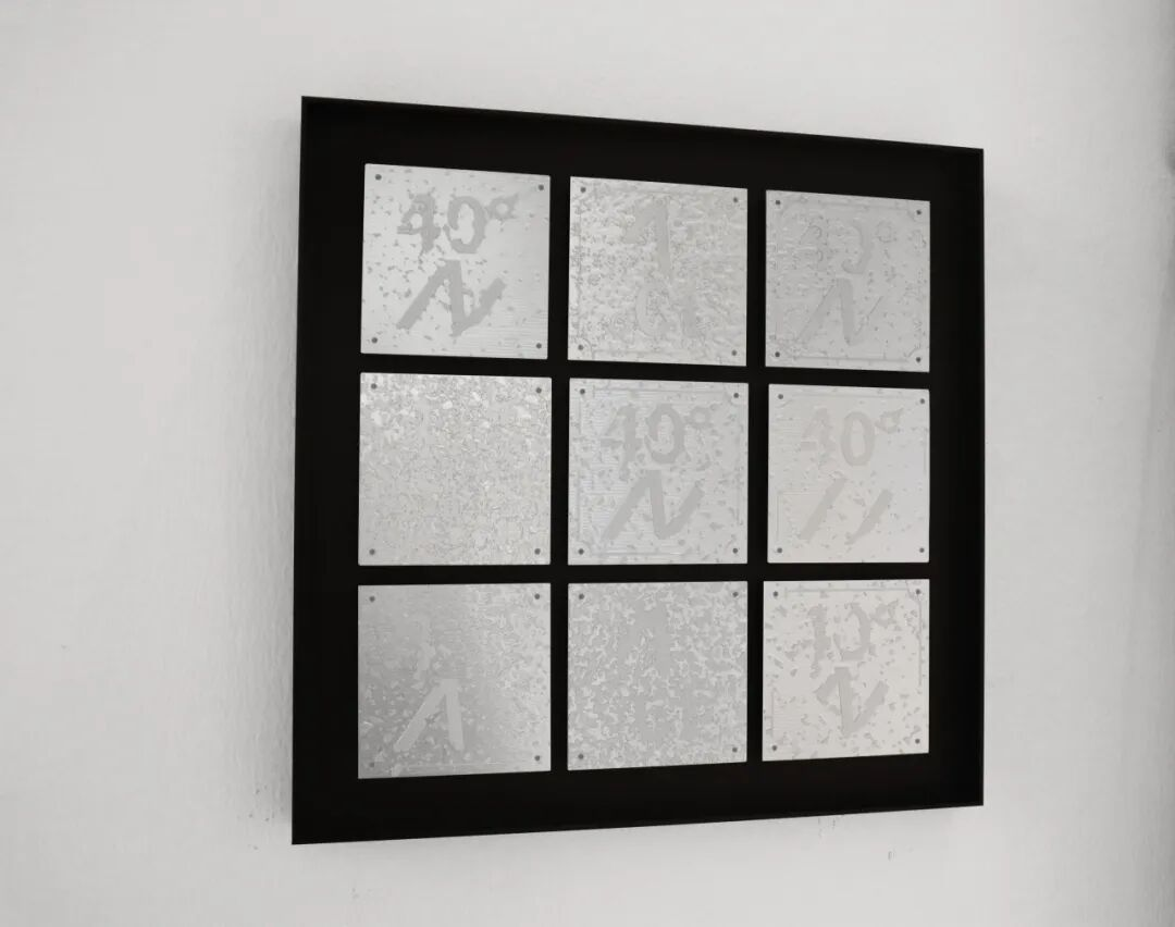 A black-framed grid with nine mirrored panels on a white wall.