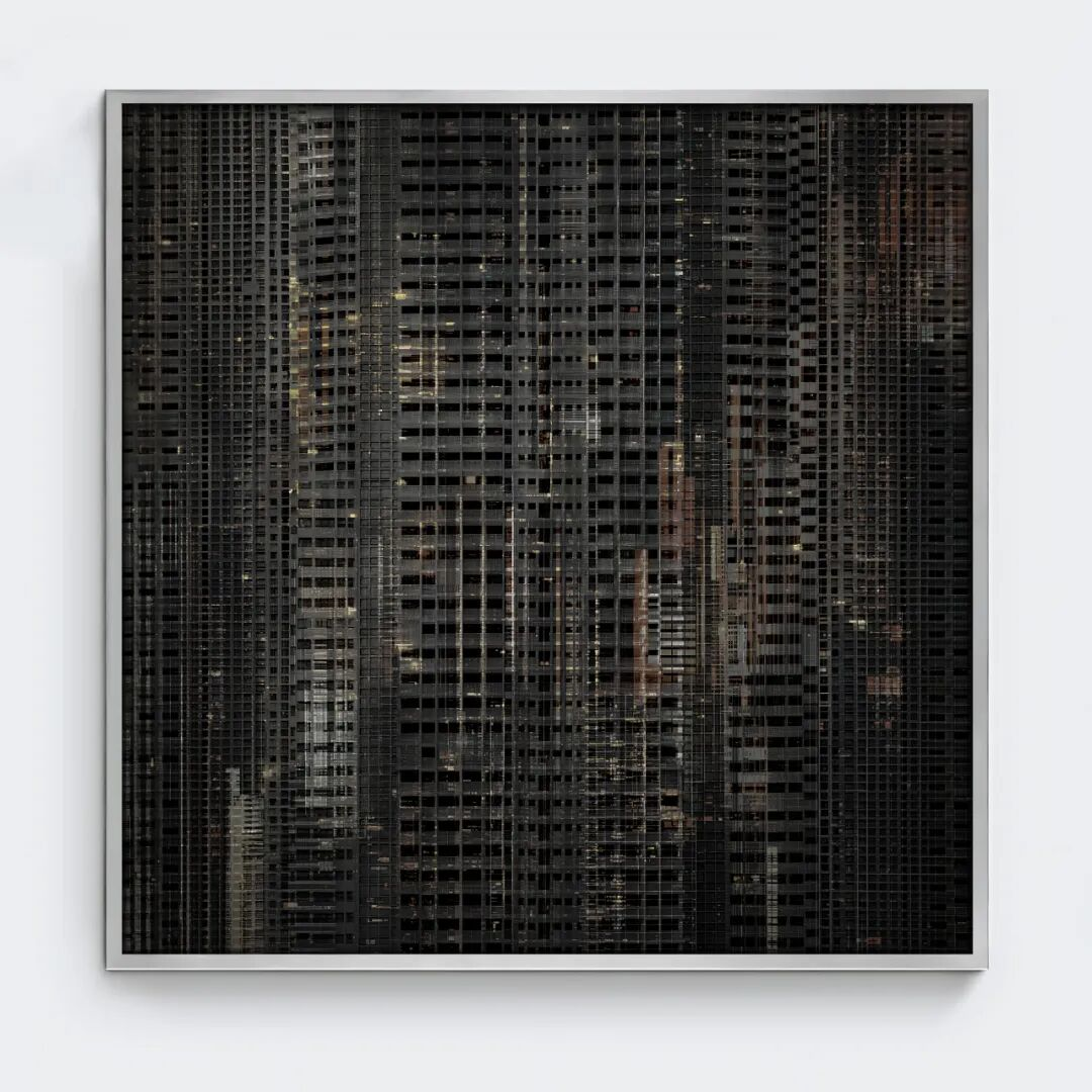 Photograph of a cityscape at night featuring multiple high-rise buildings with numerous lit windows.