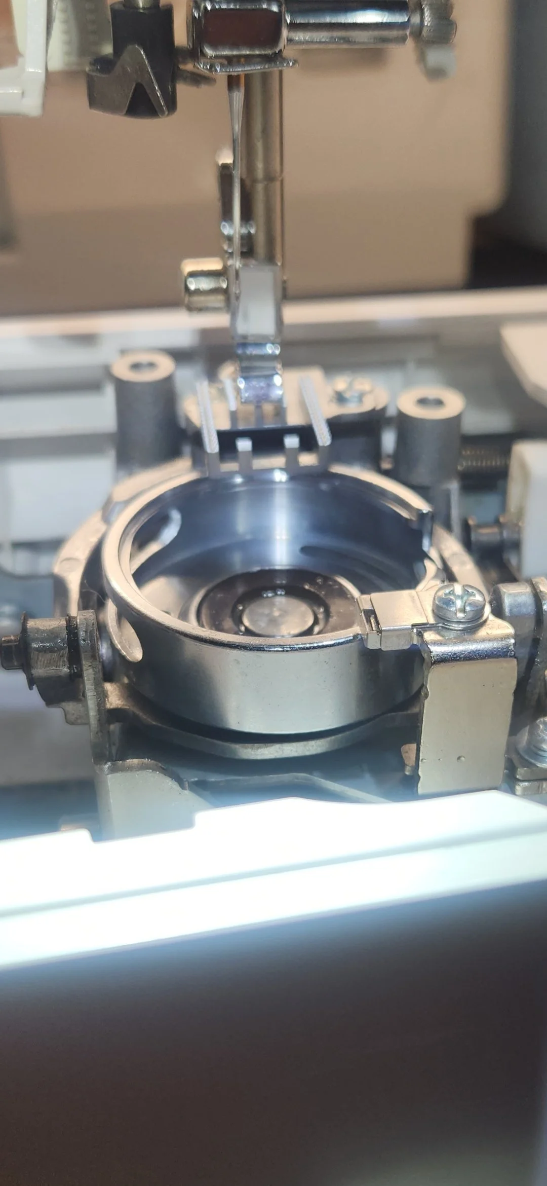 Close-up of a mechanical assembly with metallic parts, including circular components and screws, on a piece of machinery.