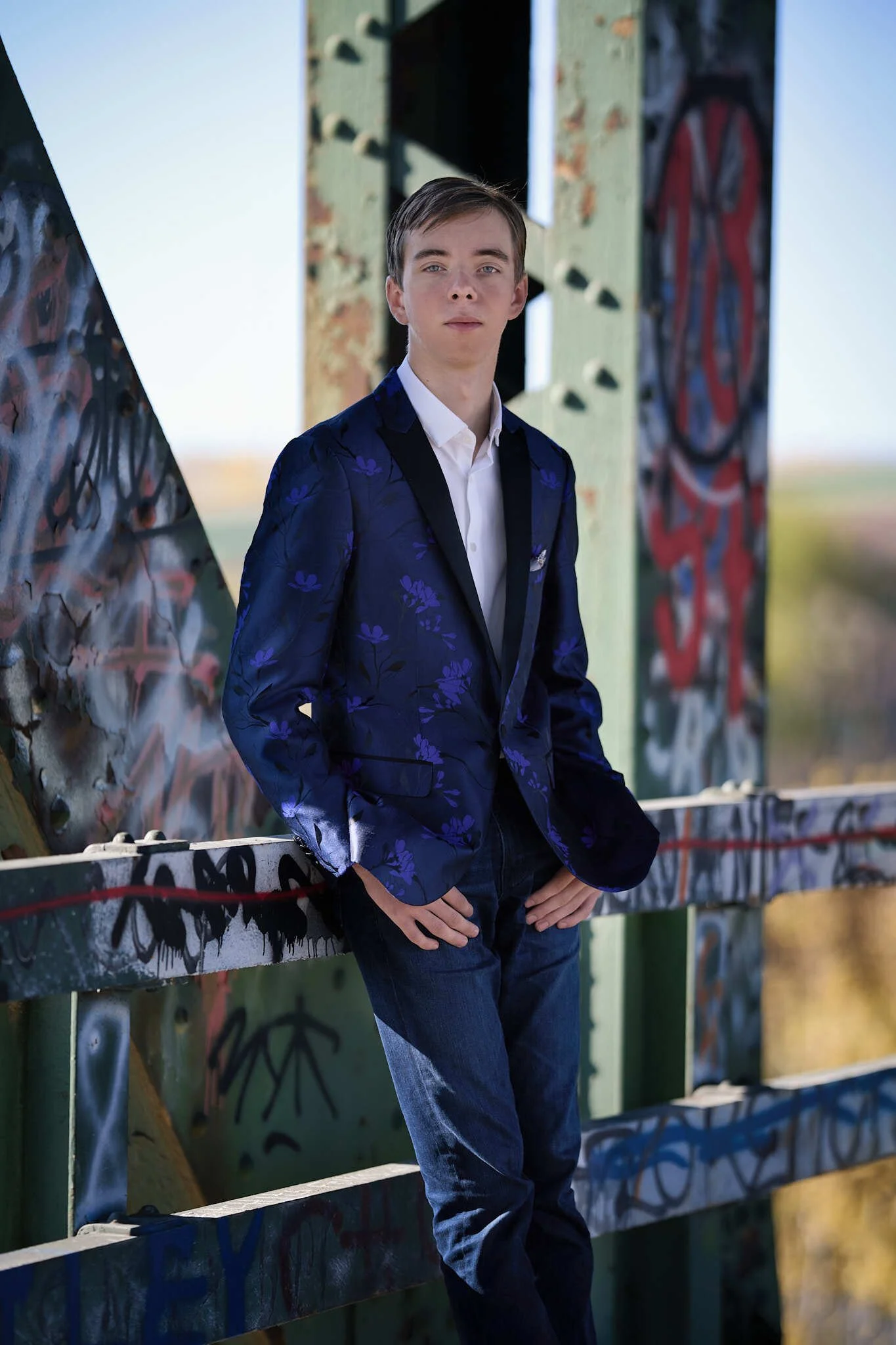 Pierce Jackson standing on a bridge in a suit.