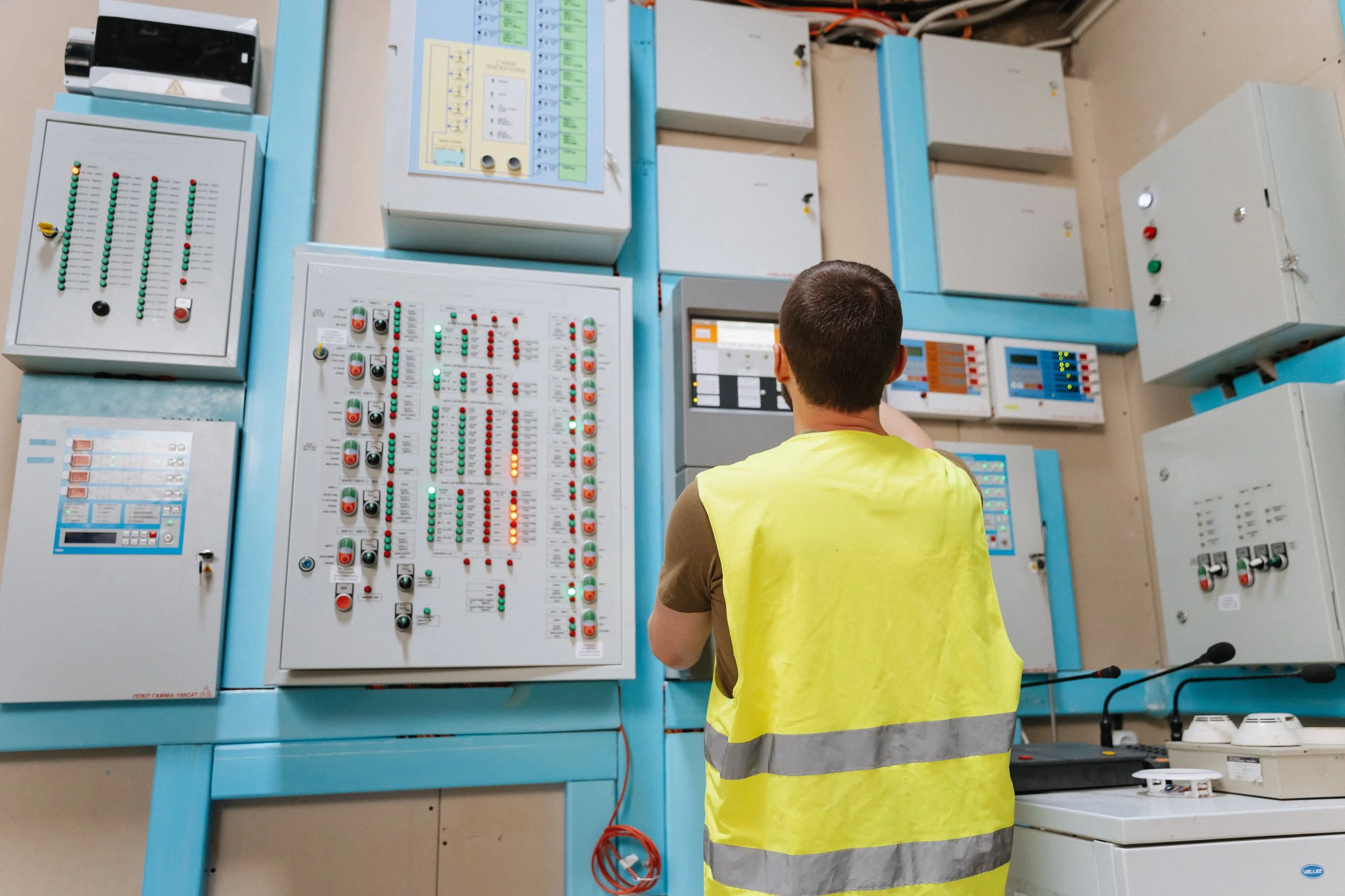 Man in safety vest looking at scada panel