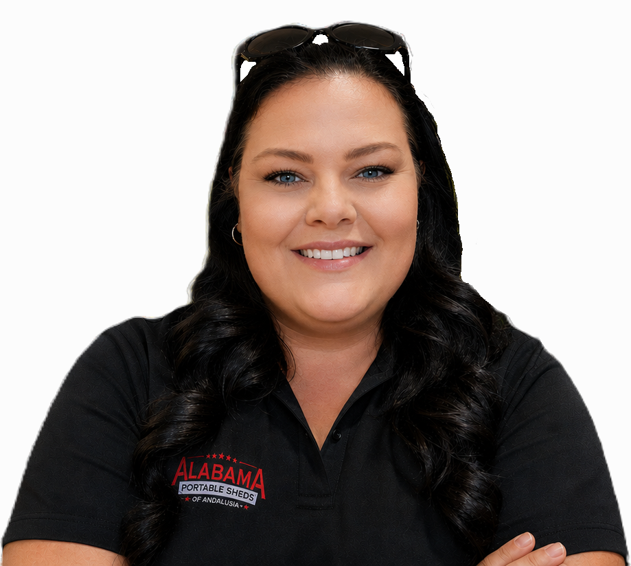 A woman with long dark hair, wearing sunglasses on her head, smiling, dressed in a black polo shirt with an Alabama Portable Sheds logo.