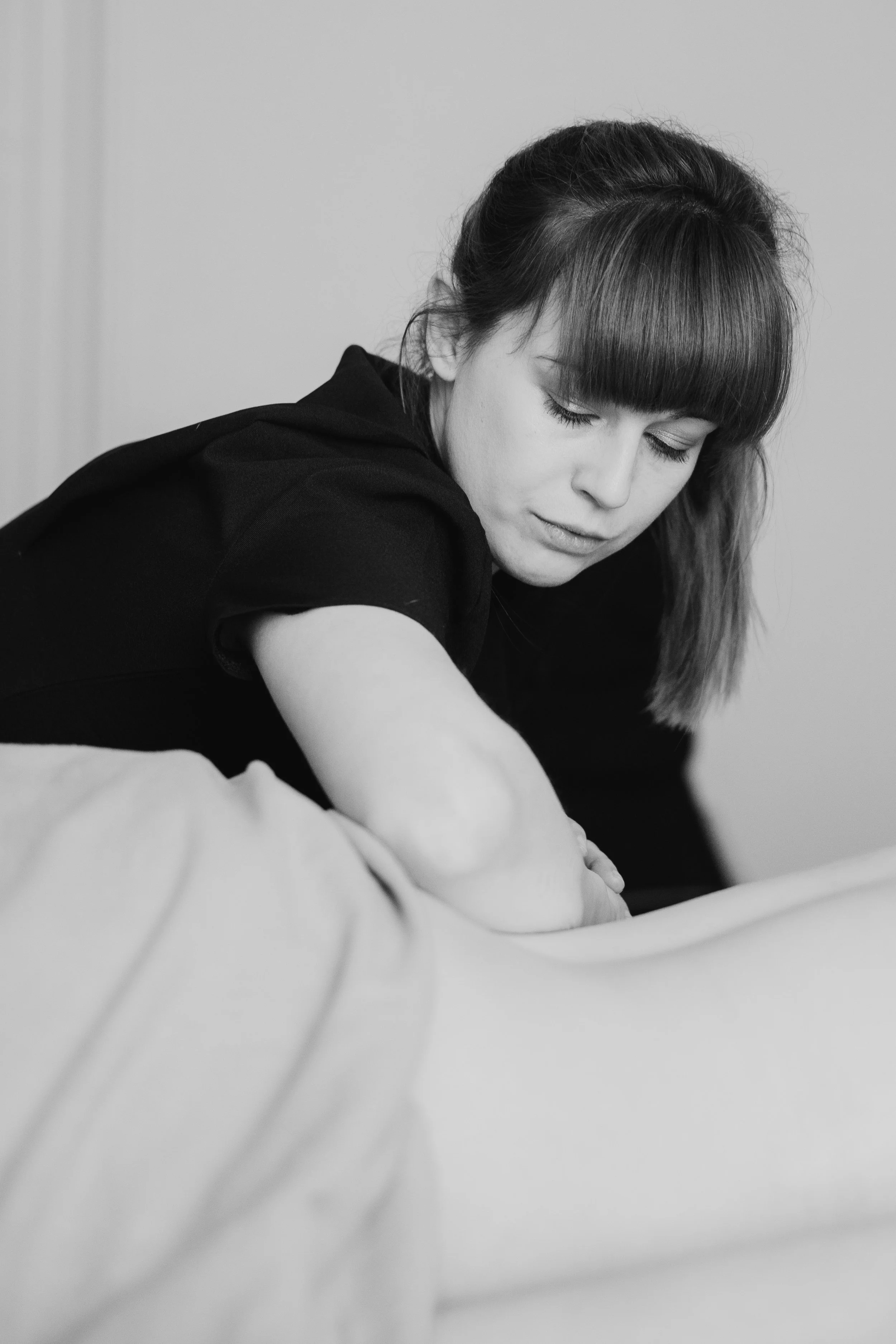 Black and white photo of Tansy practicing massage therapy.
