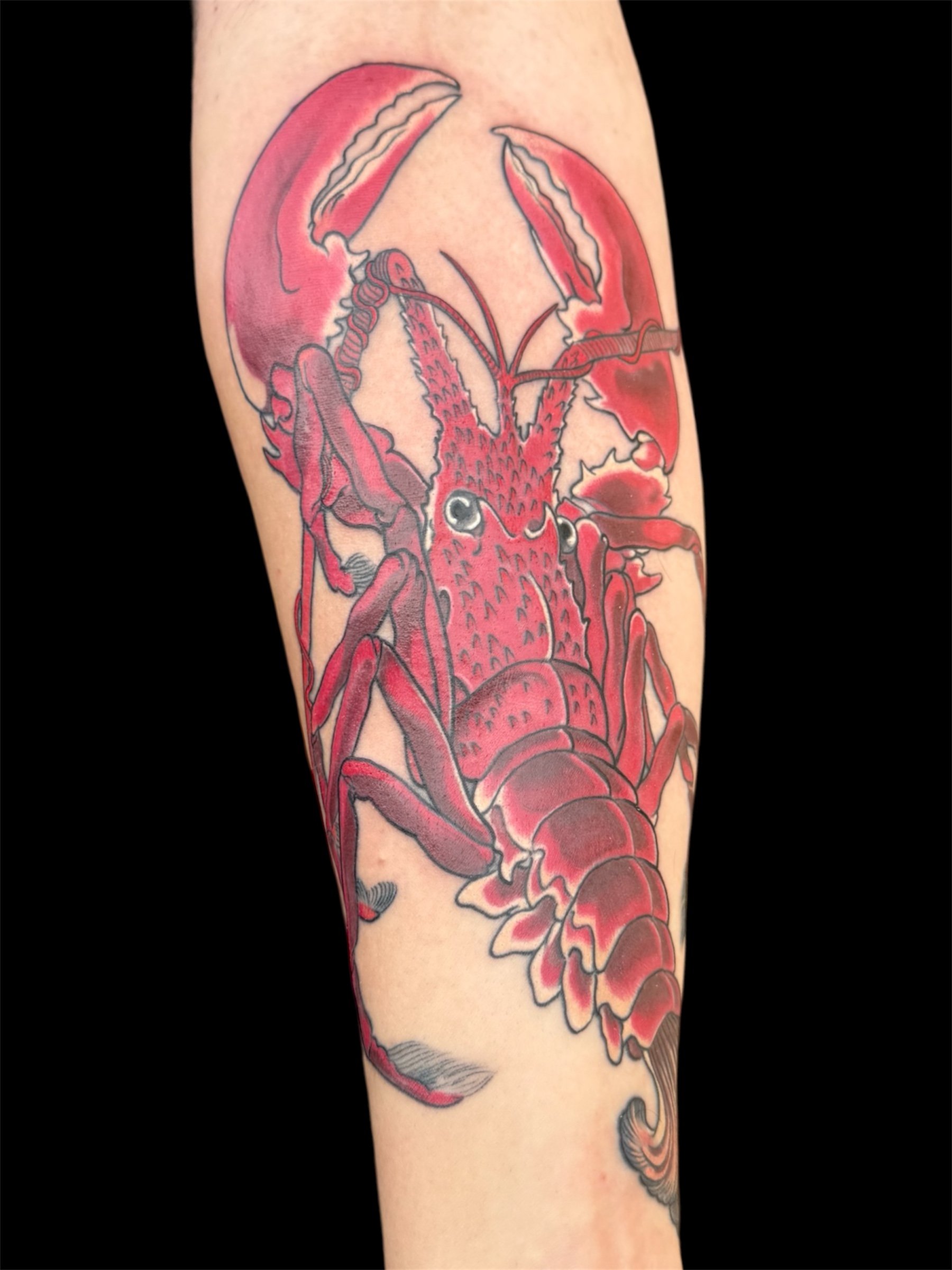 Tattoo of a red lobster on a person's arm.