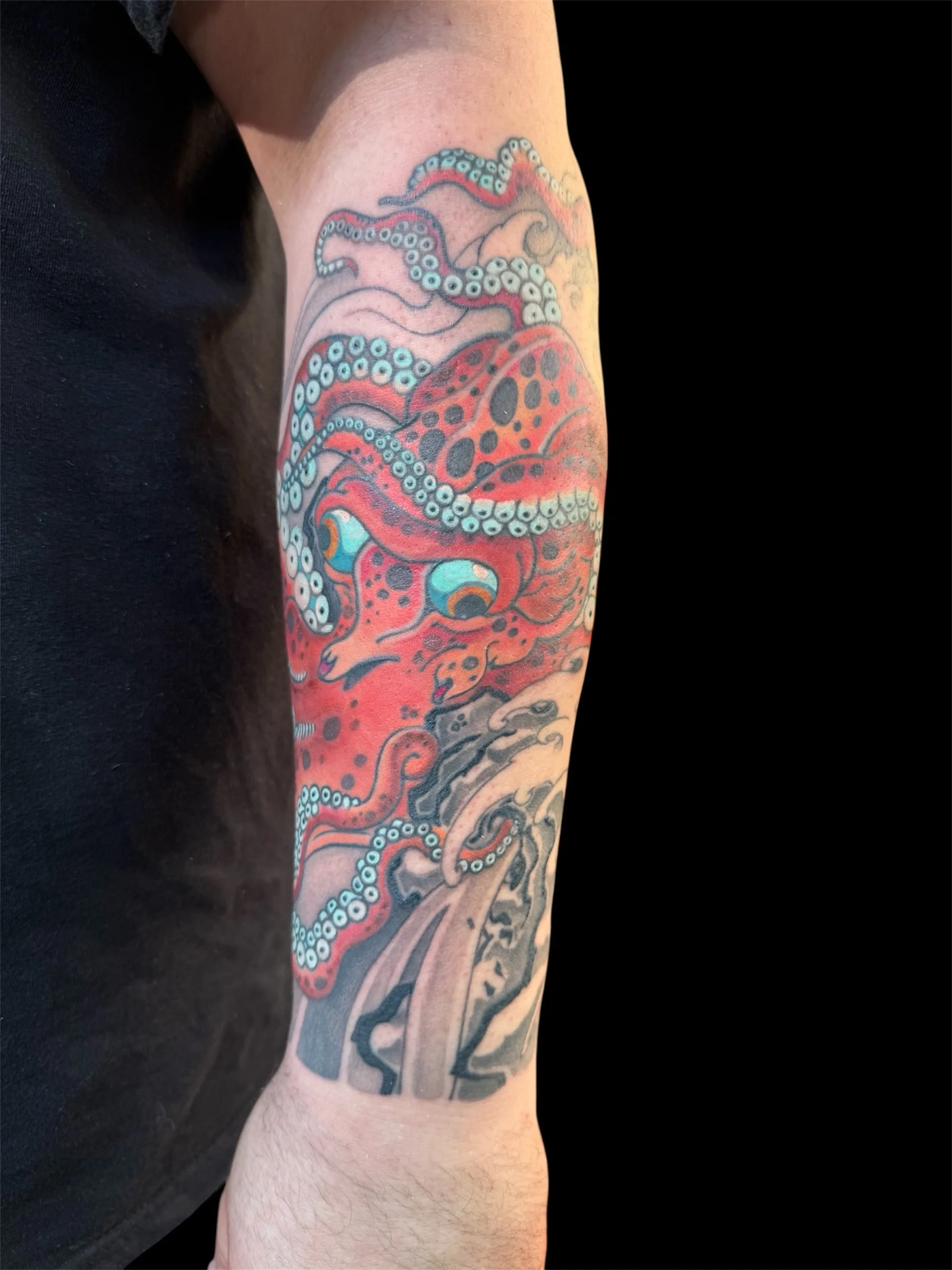 Colorful tattoo of an octopus wrapping around the arm.