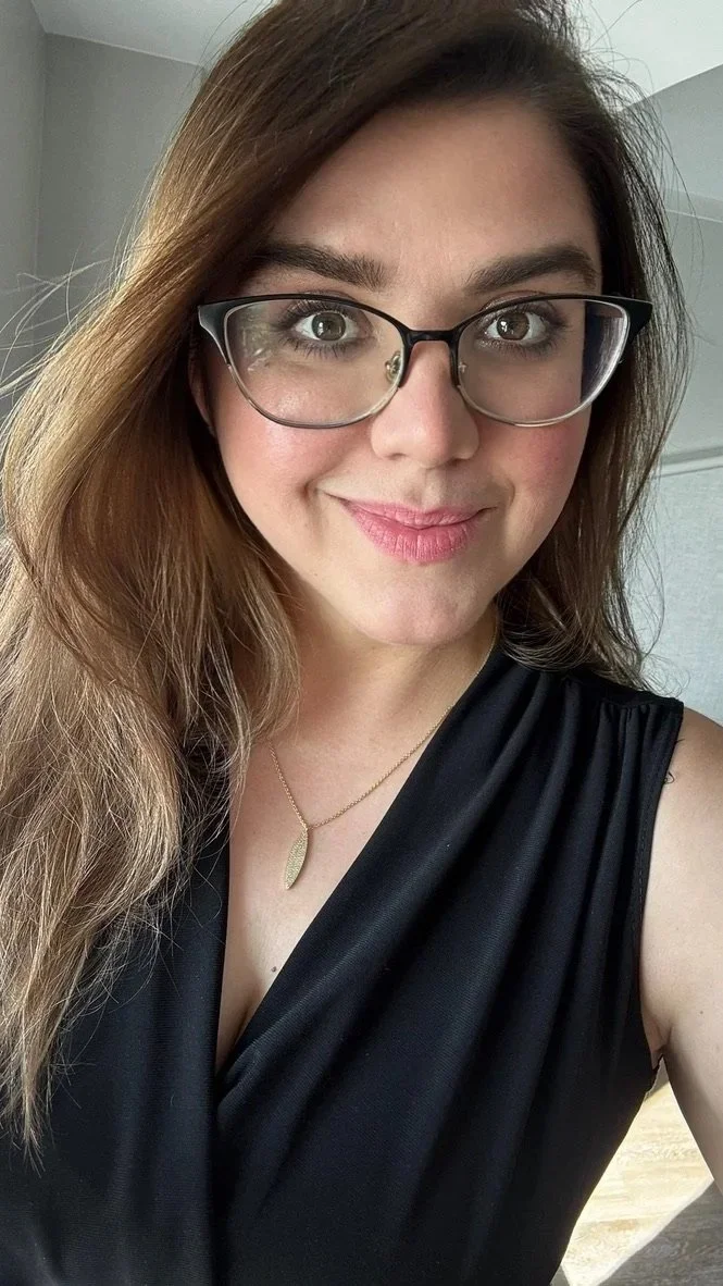 Founder of KD Travel Pro, smiling in a black sleeveless top.