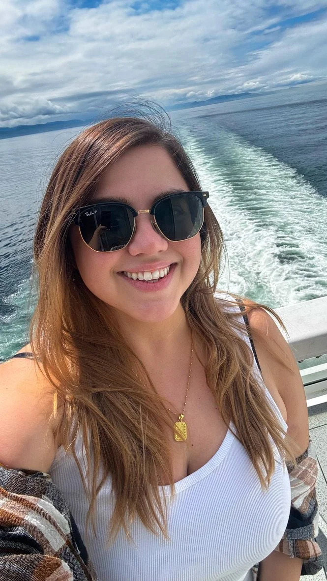 Founder of KD Travel Pro smiling on a cruise ship with the ocean wake in the background.