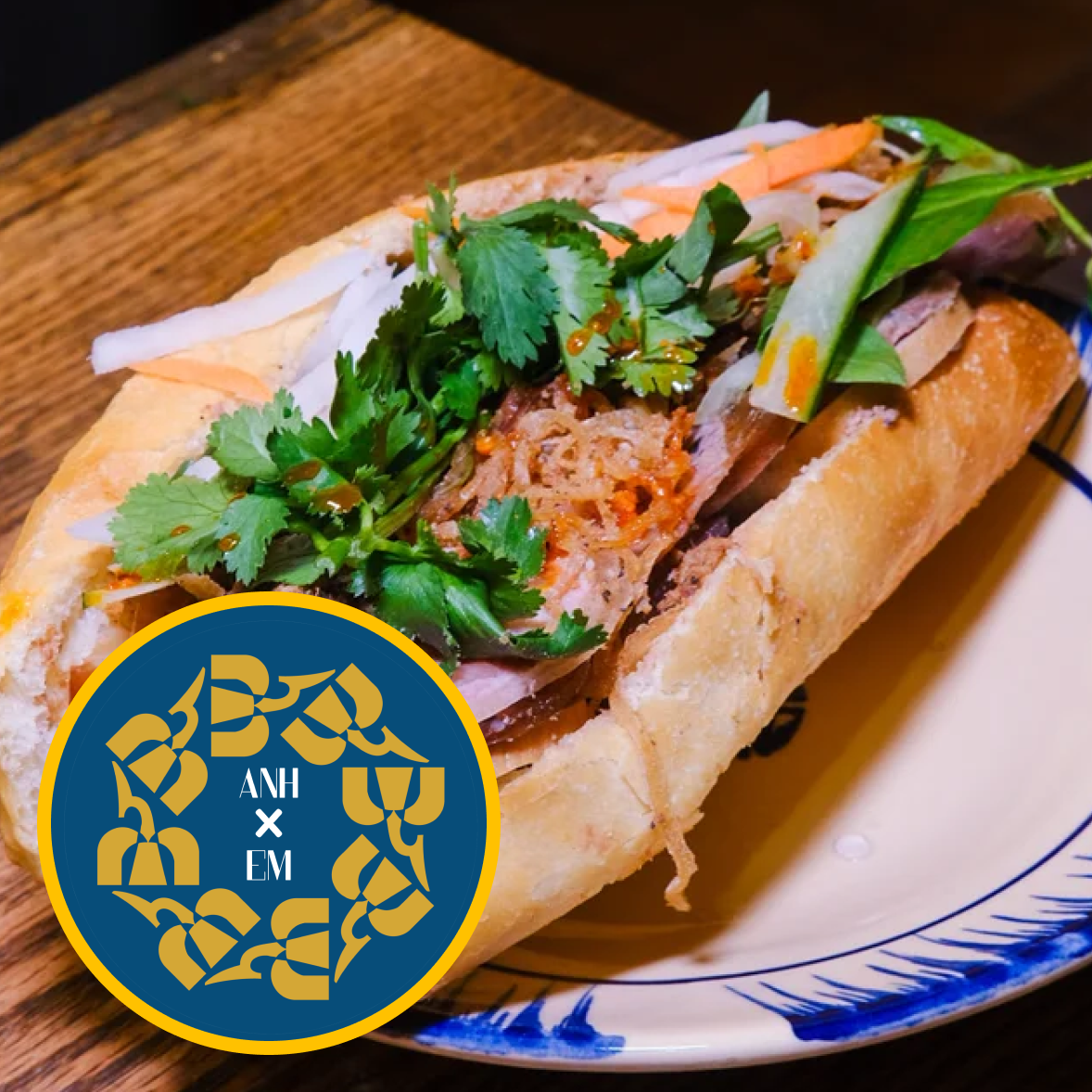 Vietnamese banh mi sandwich with pickled vegetables, fresh cilantro, and herbs on a baguette on a decorative plate.