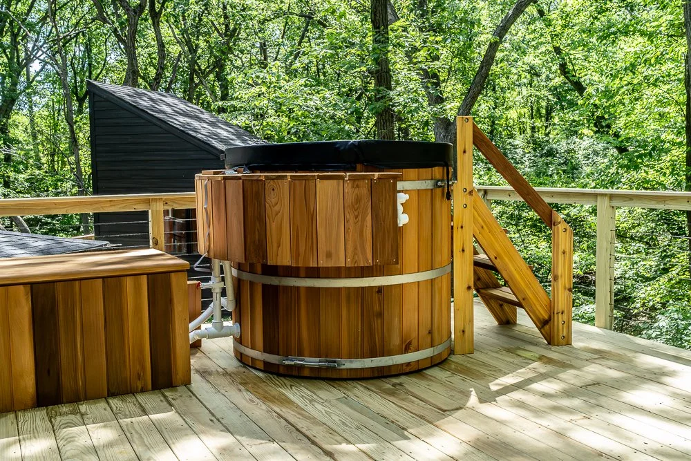 Booras Builders crafted this custom cedar hot tub for a home in Gary, and it spotlights the spacious wood deck, as do the matching integrated stairs and modern cable railing system overlooking the lush wooded property.