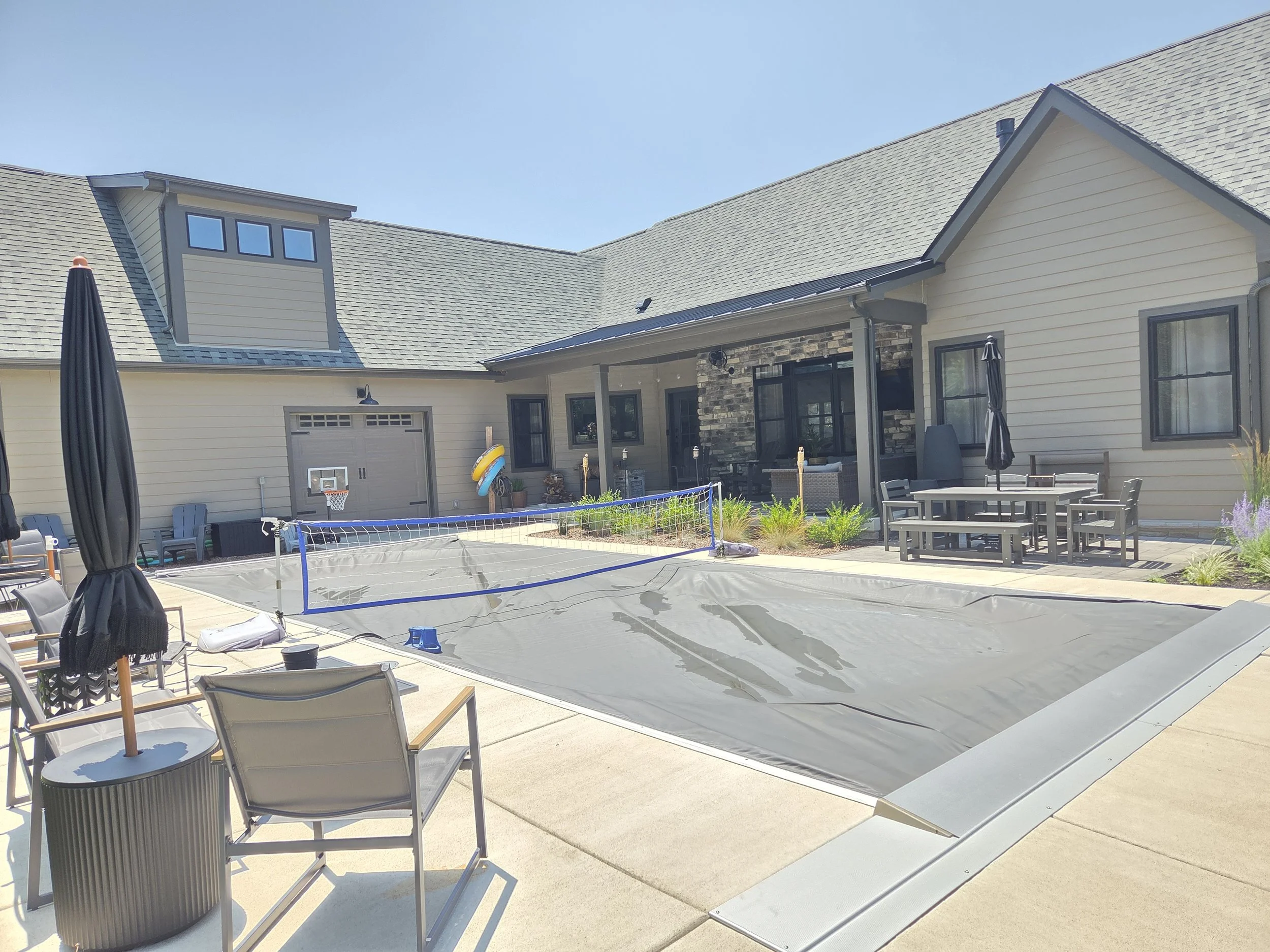 In Chesterton, Booras Builders crafted this custom home with stone accents, featuring a premium concrete patio and a unique covered pool built directly into the backyard layout.