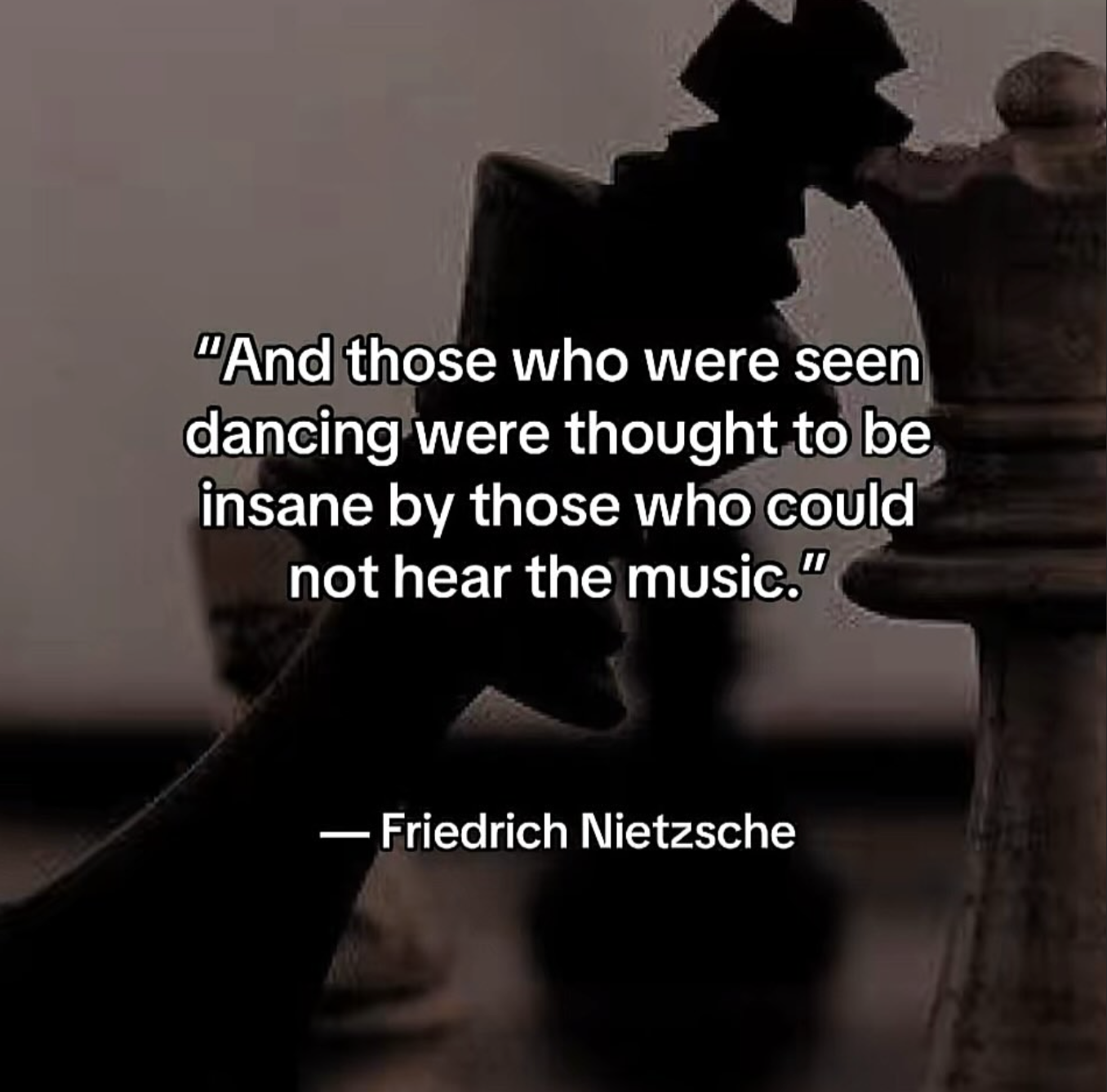 Close-up of a chessboard and chess pieces in background with overlay text of a quote by Friedrich Nietzsche about music and dancing.