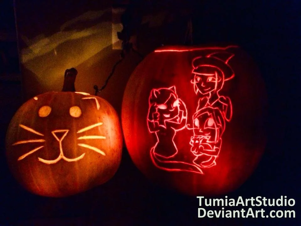 Two carved pumpkins glowing in the dark, one with a simple cat face and the other with detailed fairy tale characters outline, including a girl and a witch.
