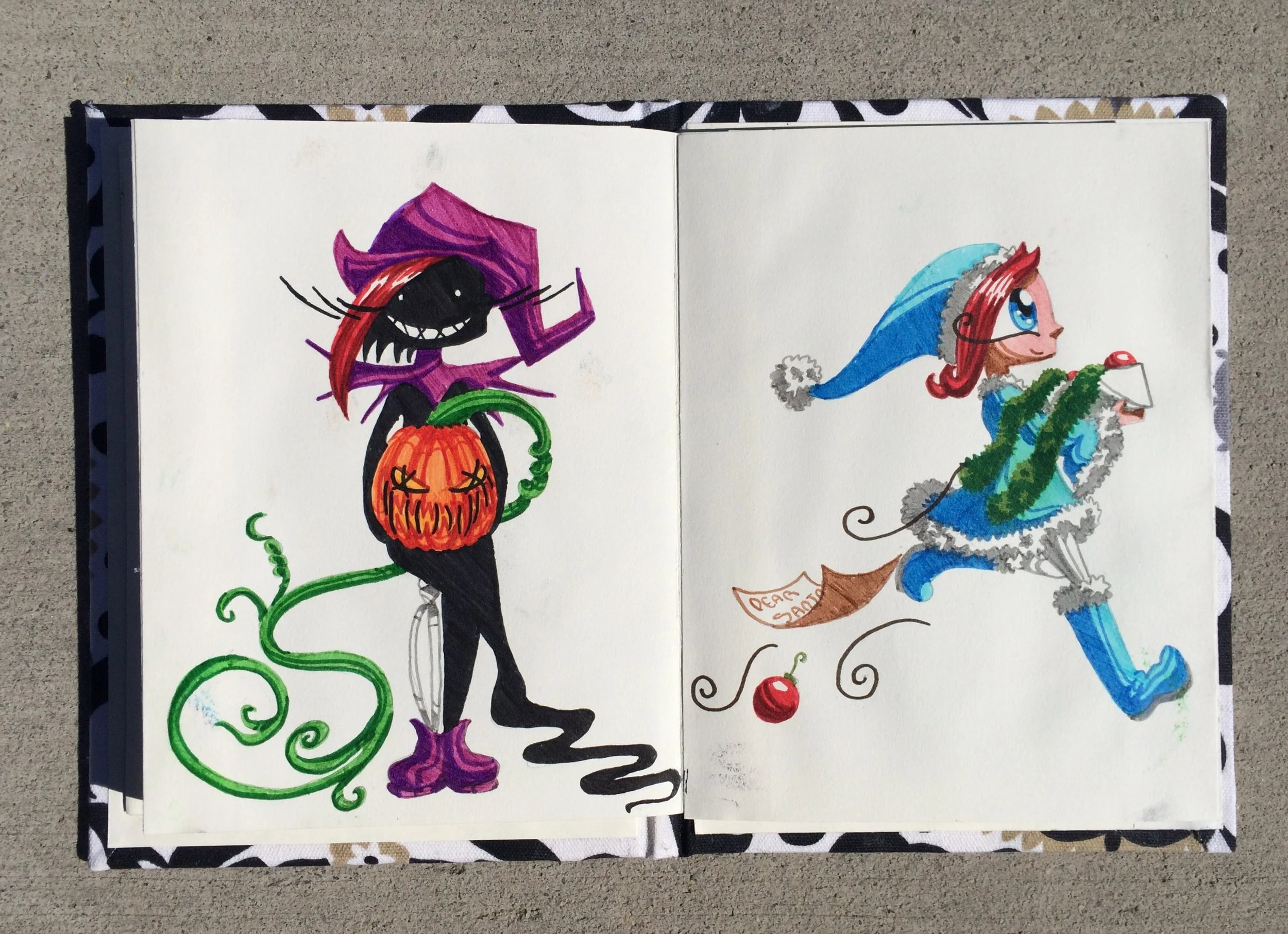 Colorful hand-drawn Halloween-themed illustration on an open book showing a black cat in a purple hat holding a pumpkin, and a girl in a blue winter outfit with a hat holding a candy cane.