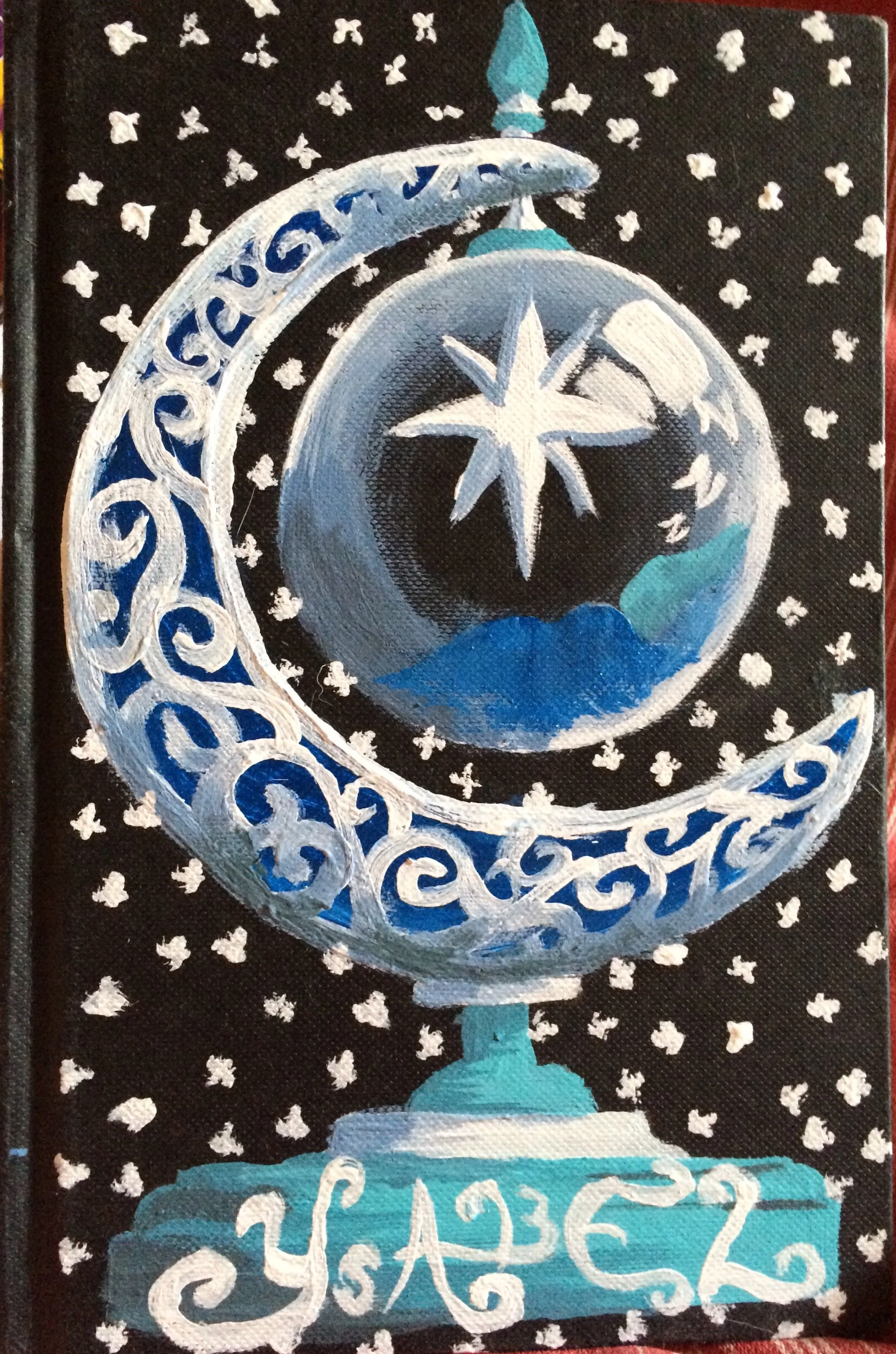 A decorative painting of a blue and white champagne glass with a star inside the glass, topped with a sparkler, set against a black background with white dots resembling snow.