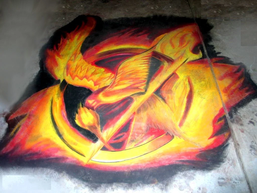 Colorful chalk art depicting a flaming sword and a fiery background in orange, yellow, and red tones on a dark surface.