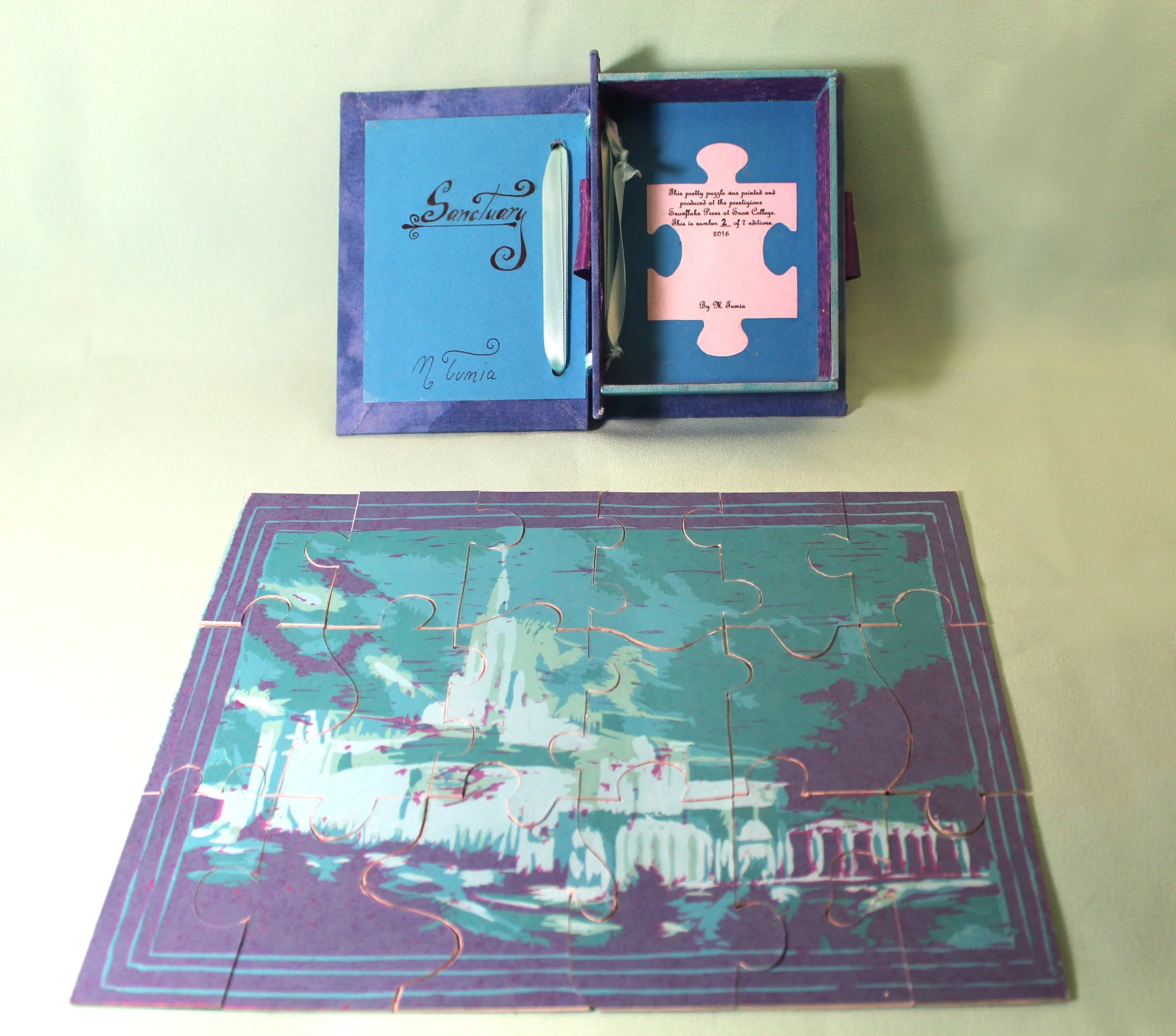 A partially assembled blue and purple jigsaw puzzle depicting a floral design on a light-colored surface.
